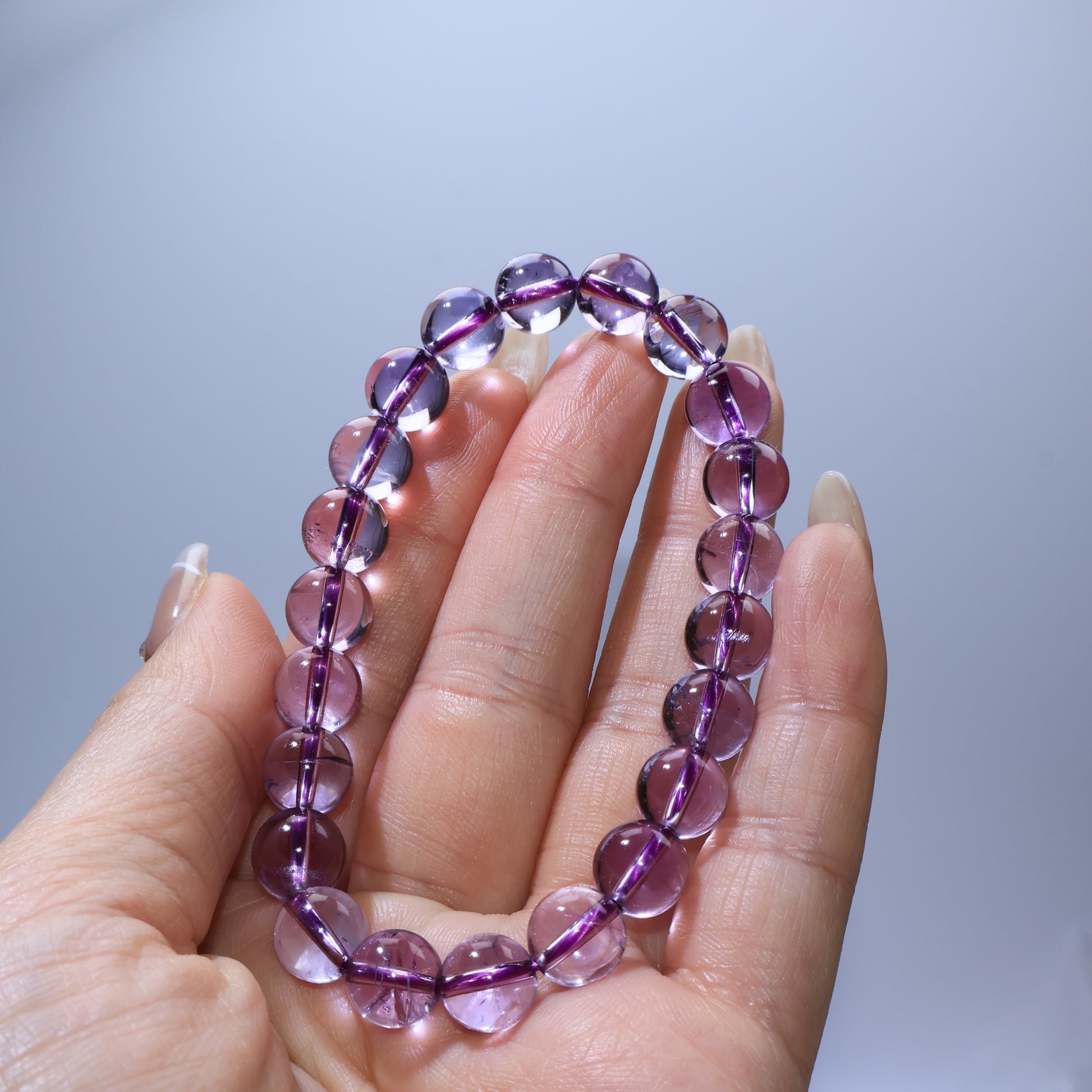 Handheld view of Dreamlight Amethyst bracelet, highlighting clarity and even bead size