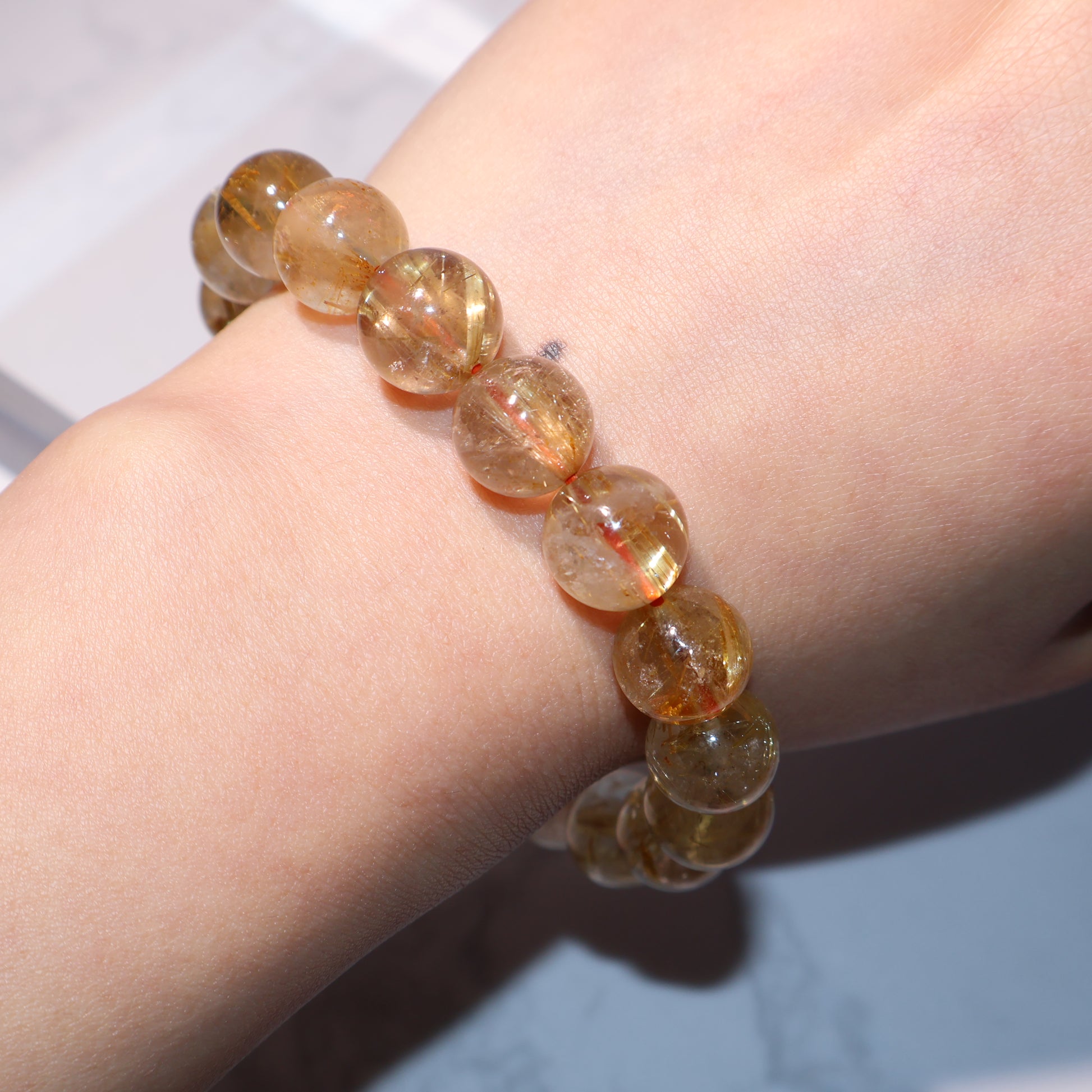 Wrist view from side – sparkling rutile strands inside clear beads