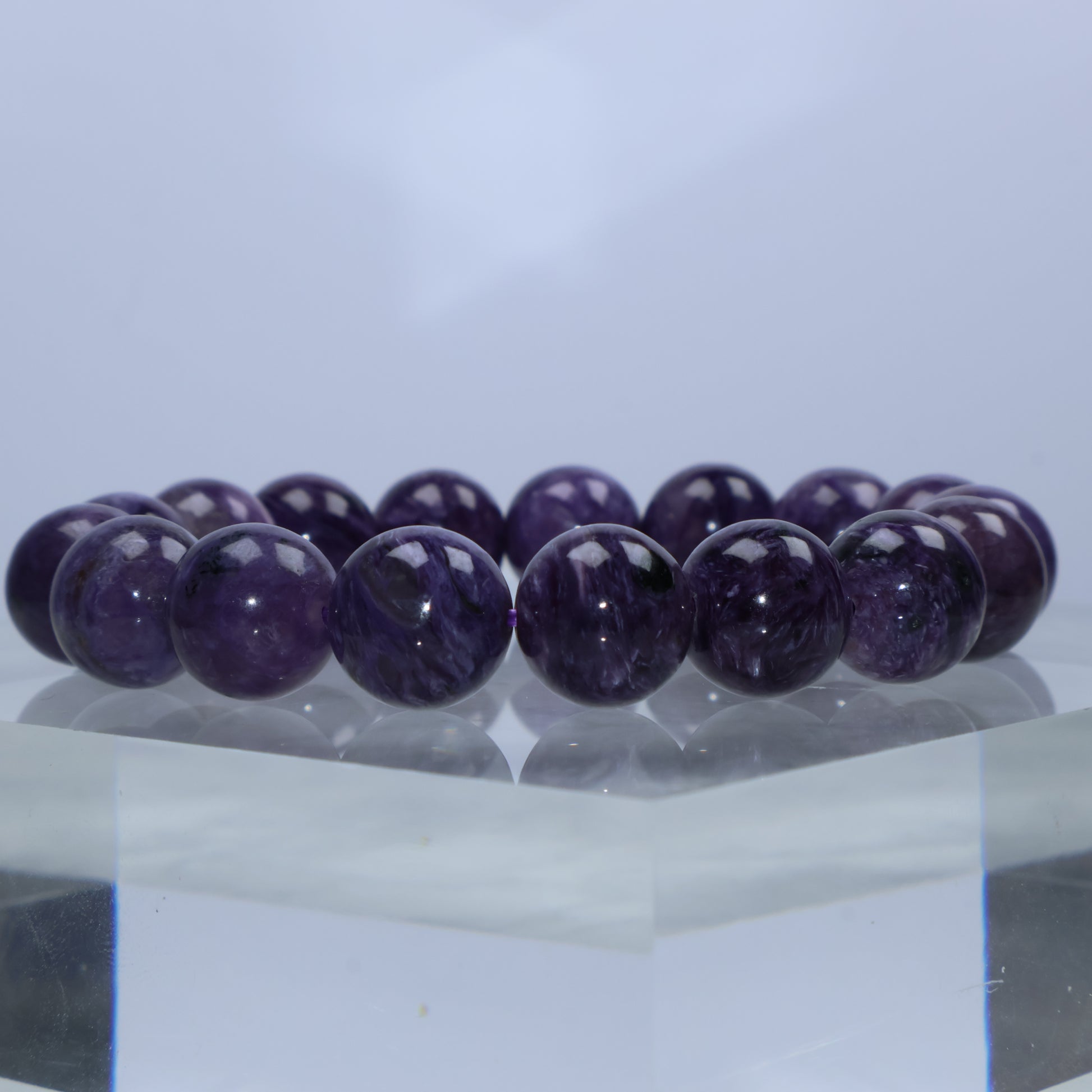 Close-up of richly saturated Charoite beads with fibrous swirls