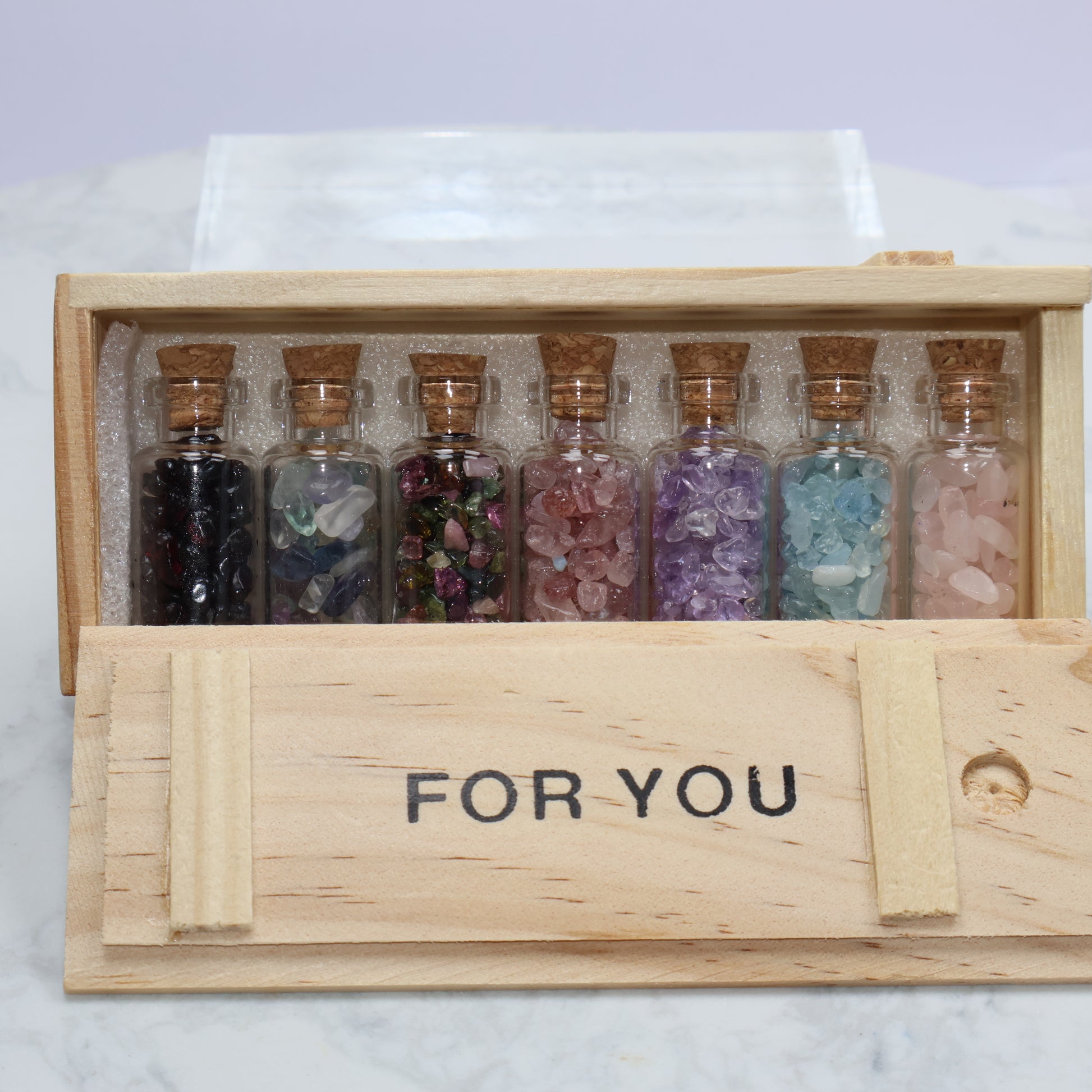 Open box with sliding lid showing 7 crystal bottles inside labeled ‘FOR YOU’