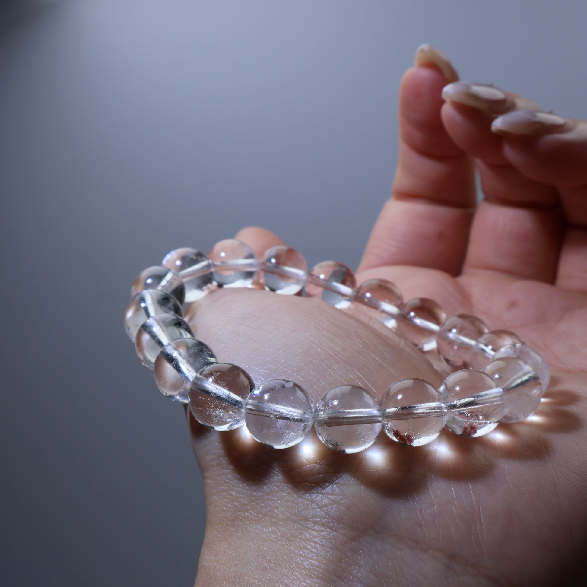 Palm view – 10mm round clear quartz beads from Brazil