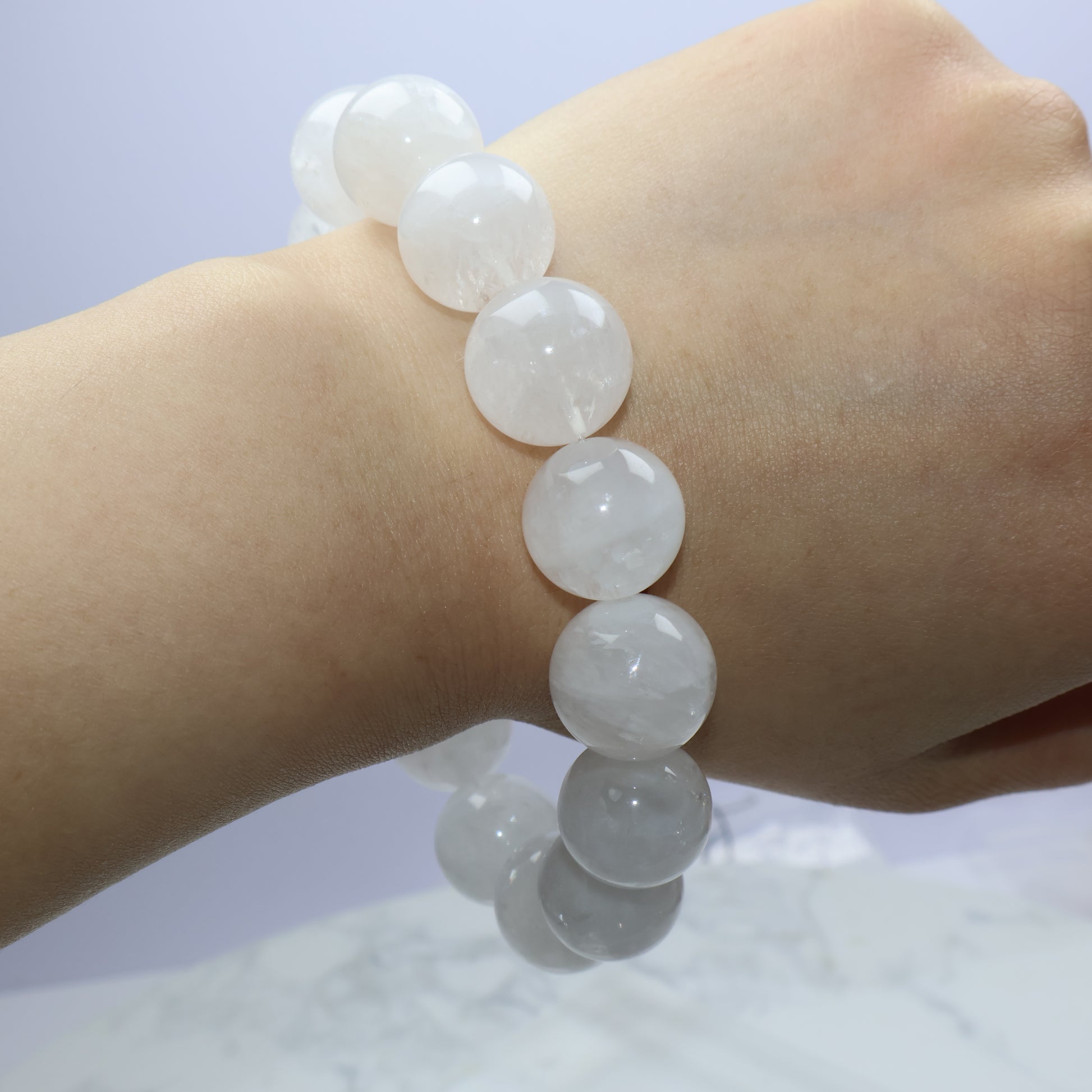 Full wrist wrap view, beads arcing around arm with soft lighting