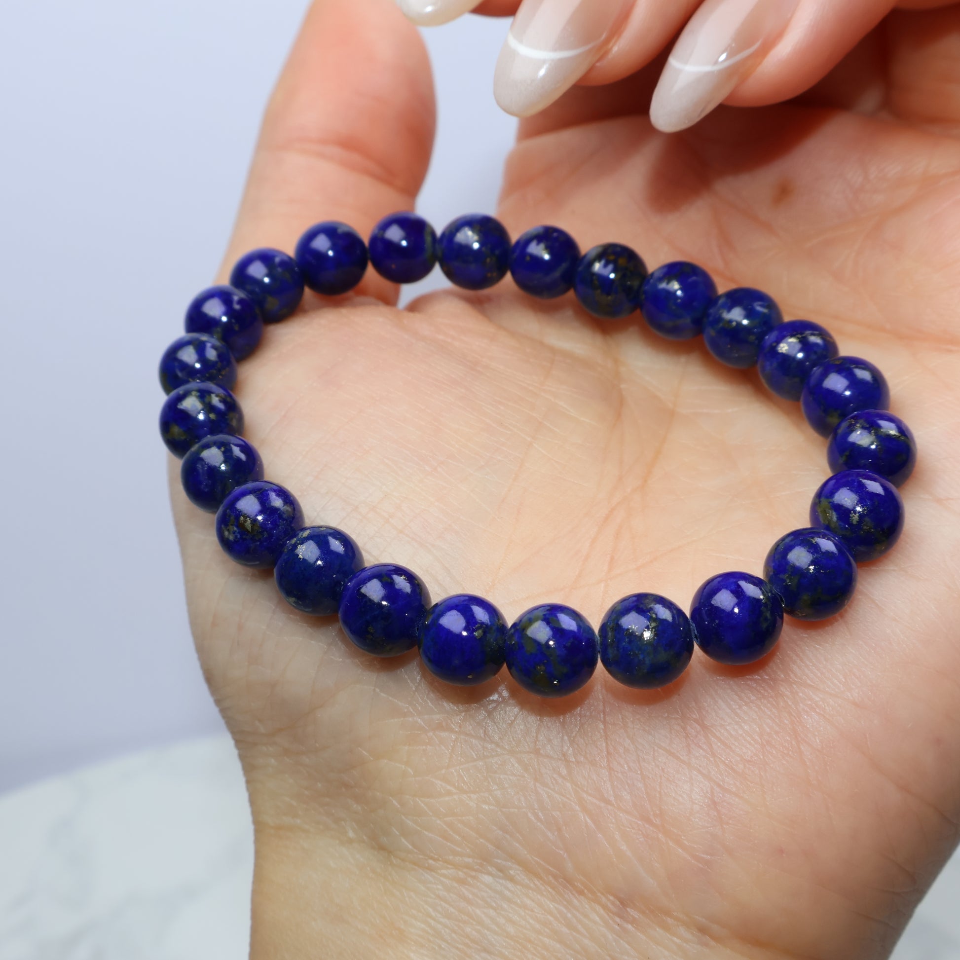 Bracelet lightly held between fingers, showing smooth texture