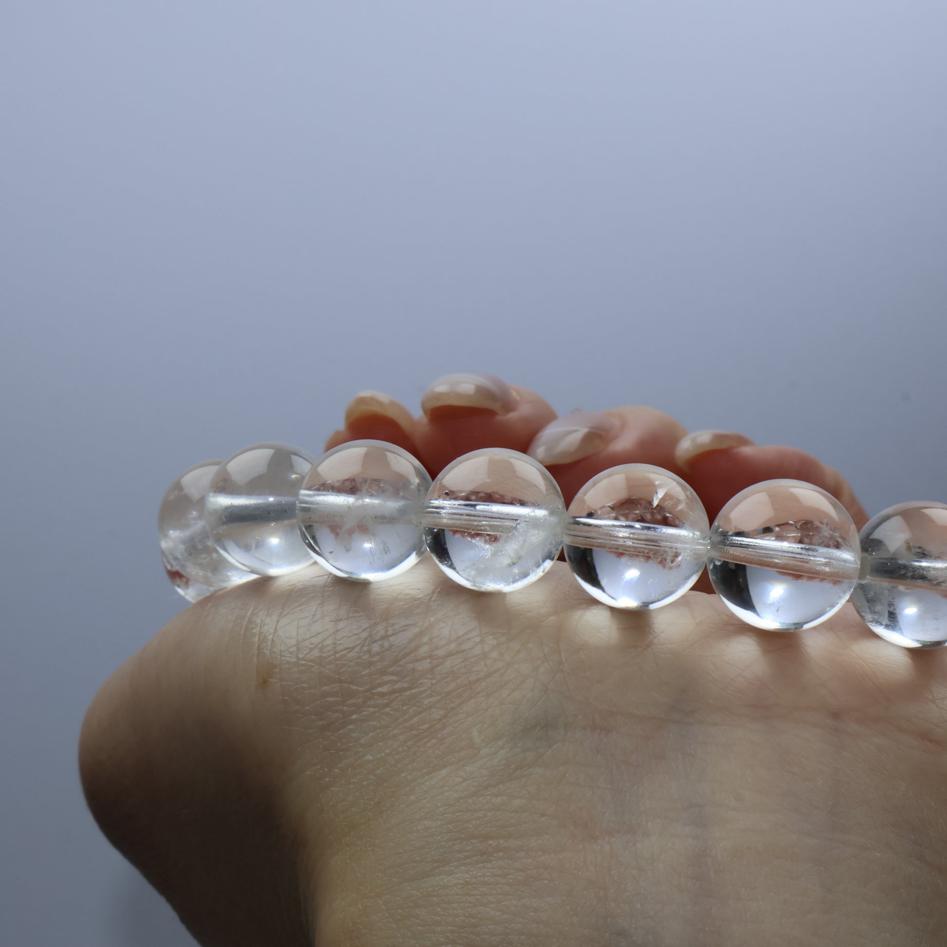 Close-up of clear quartz bracelet worn on wrist with soft lighting