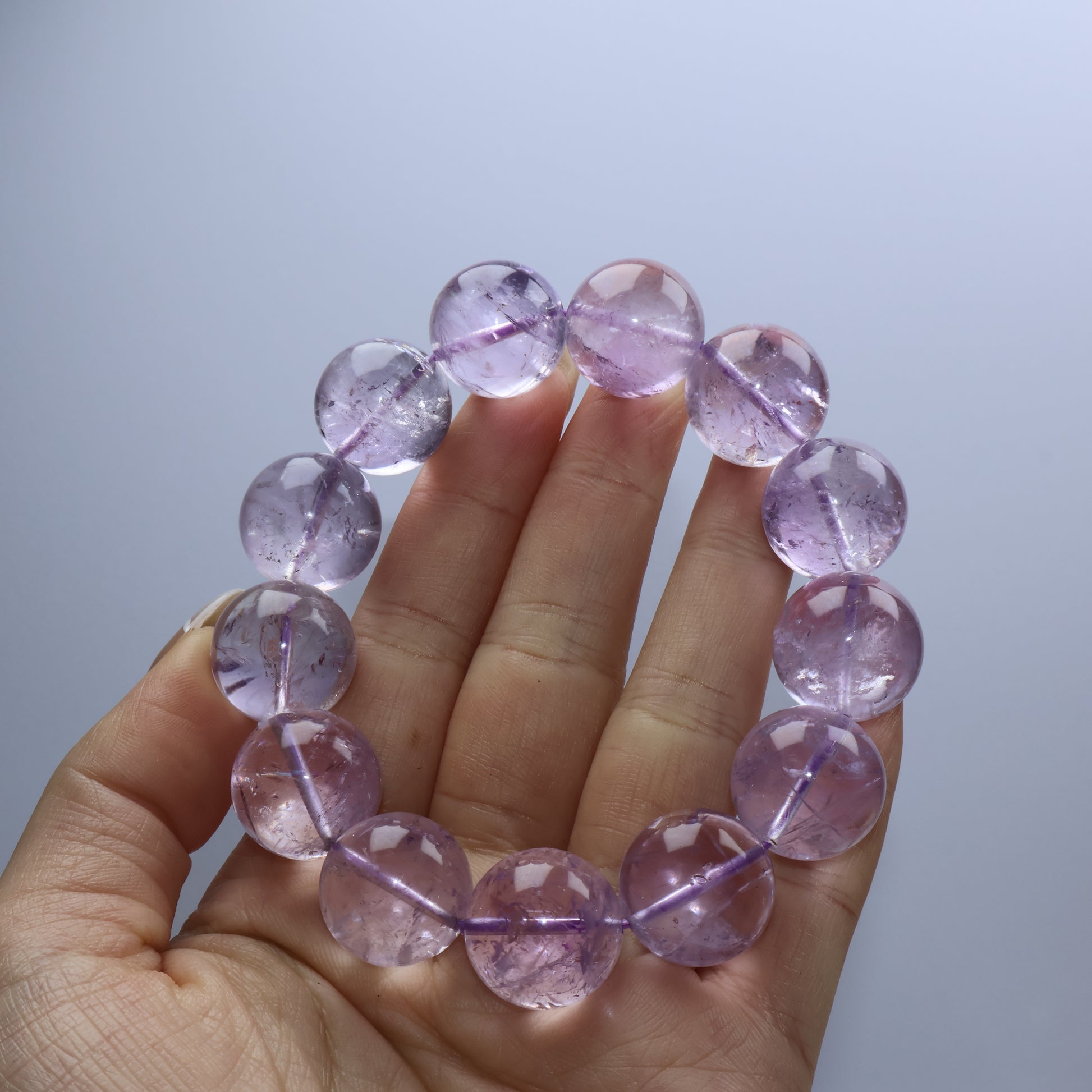 Handheld view of misty amethyst crystal bracelet with ice fissures
