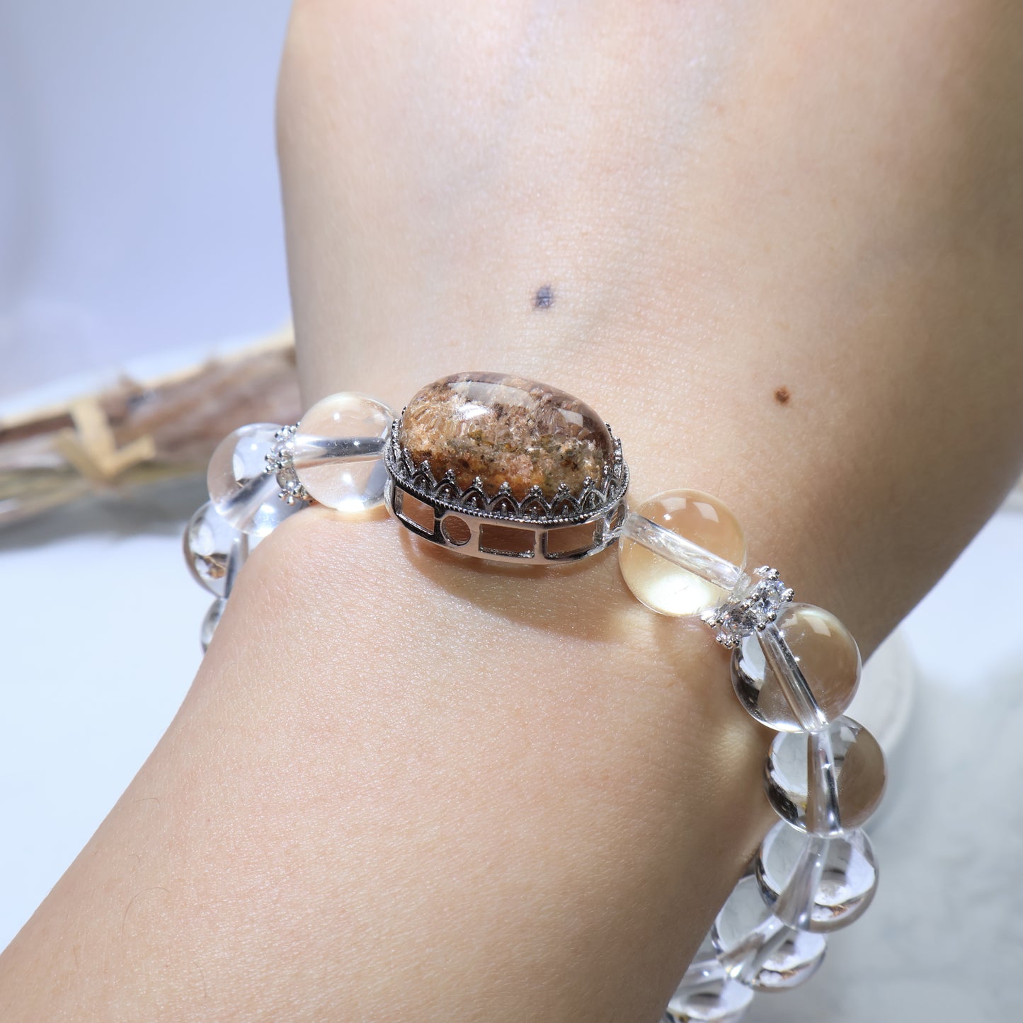 Wrist shot angled from above, capturing entire bracelet and gemstone sparkle under light