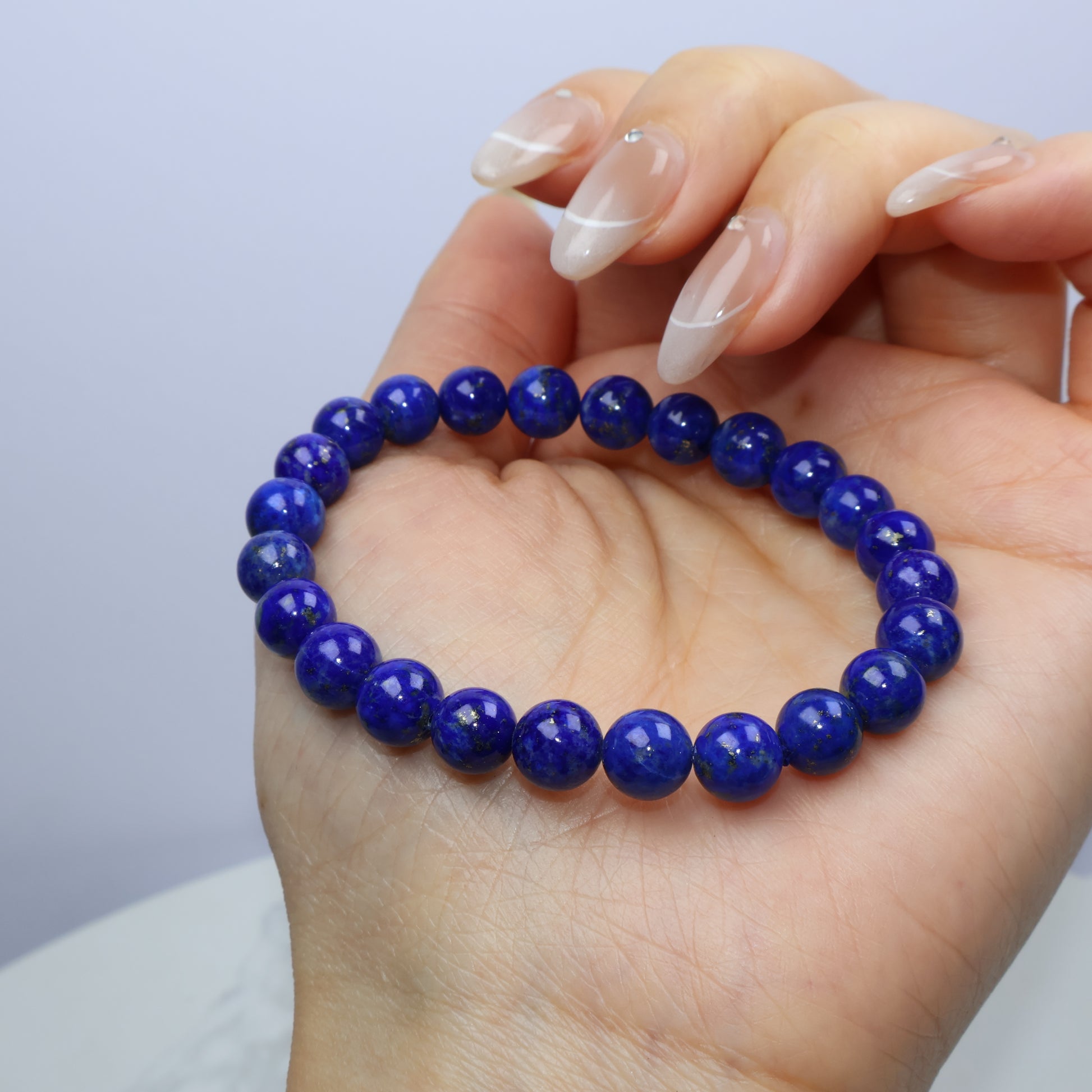 Natural daylight on lapis beads, emphasizing golden flecks