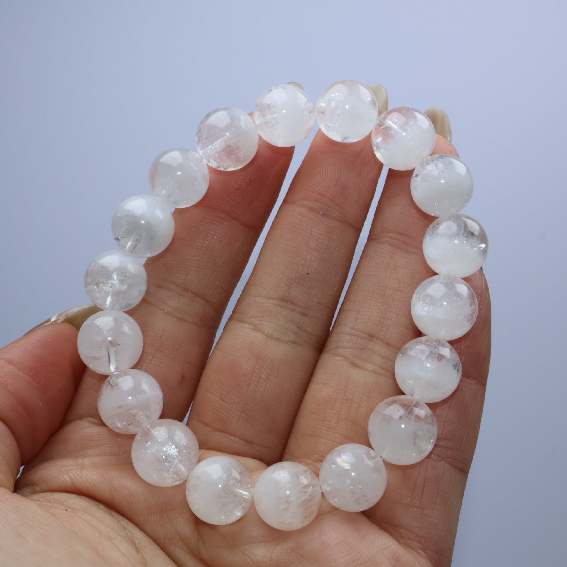 Handheld view of White Phantom Quartz bracelet with visible internal phantoms