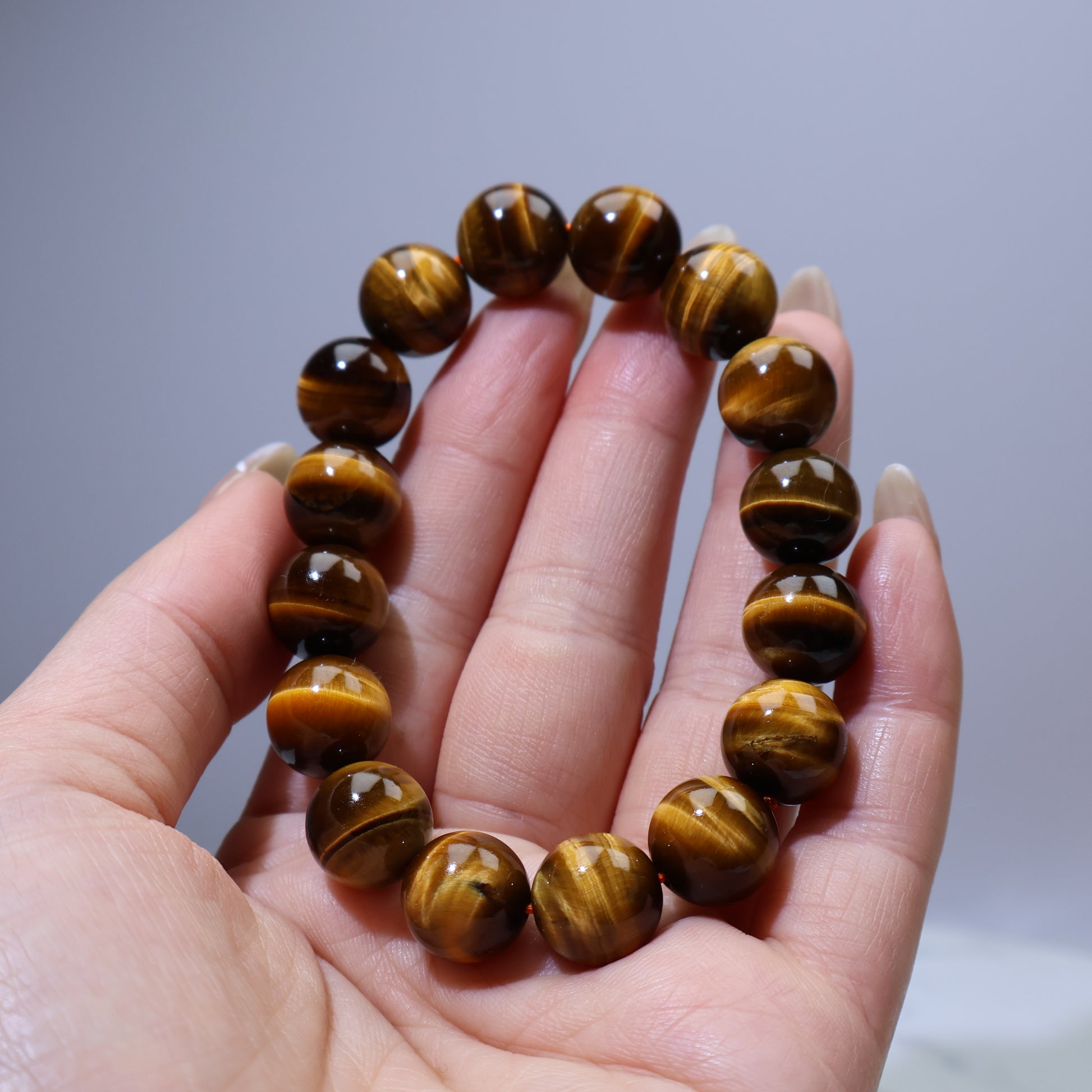 Handheld view of Tiger’s Eye bracelet with round 12mm beads