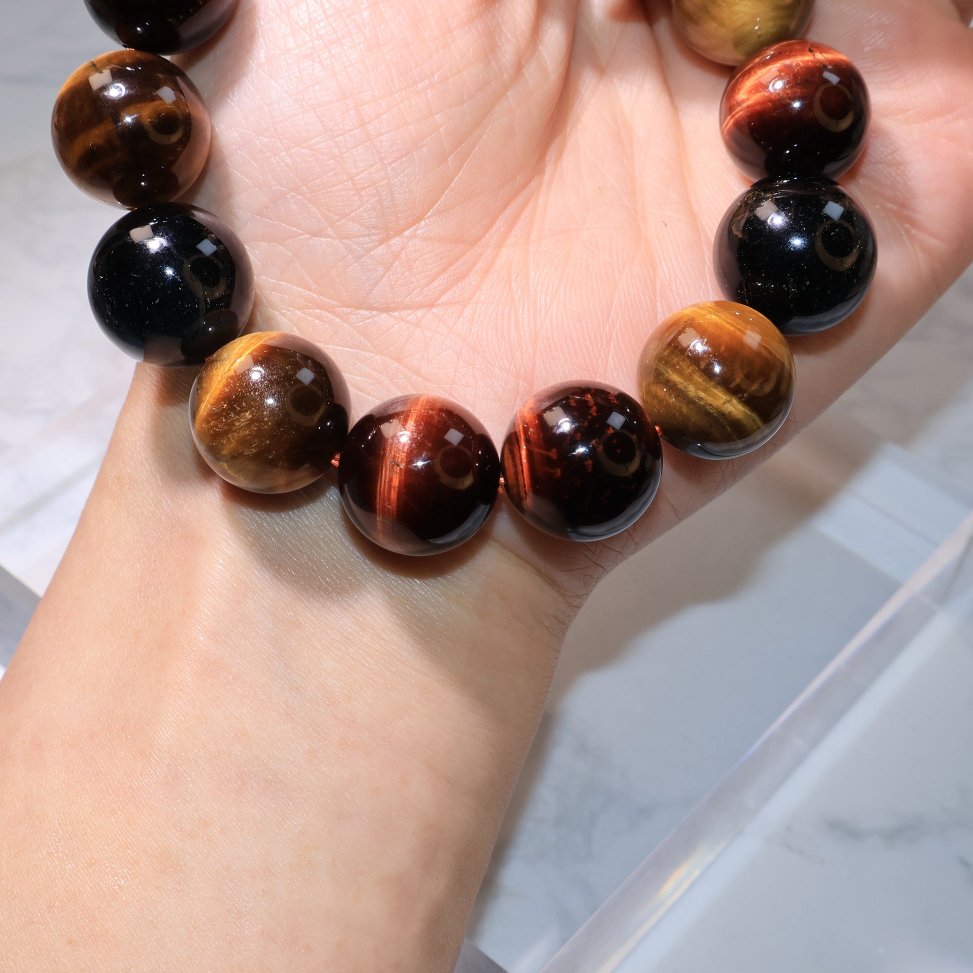 Macro shot of beads showing golden, red, and blue stripes with high polish.
