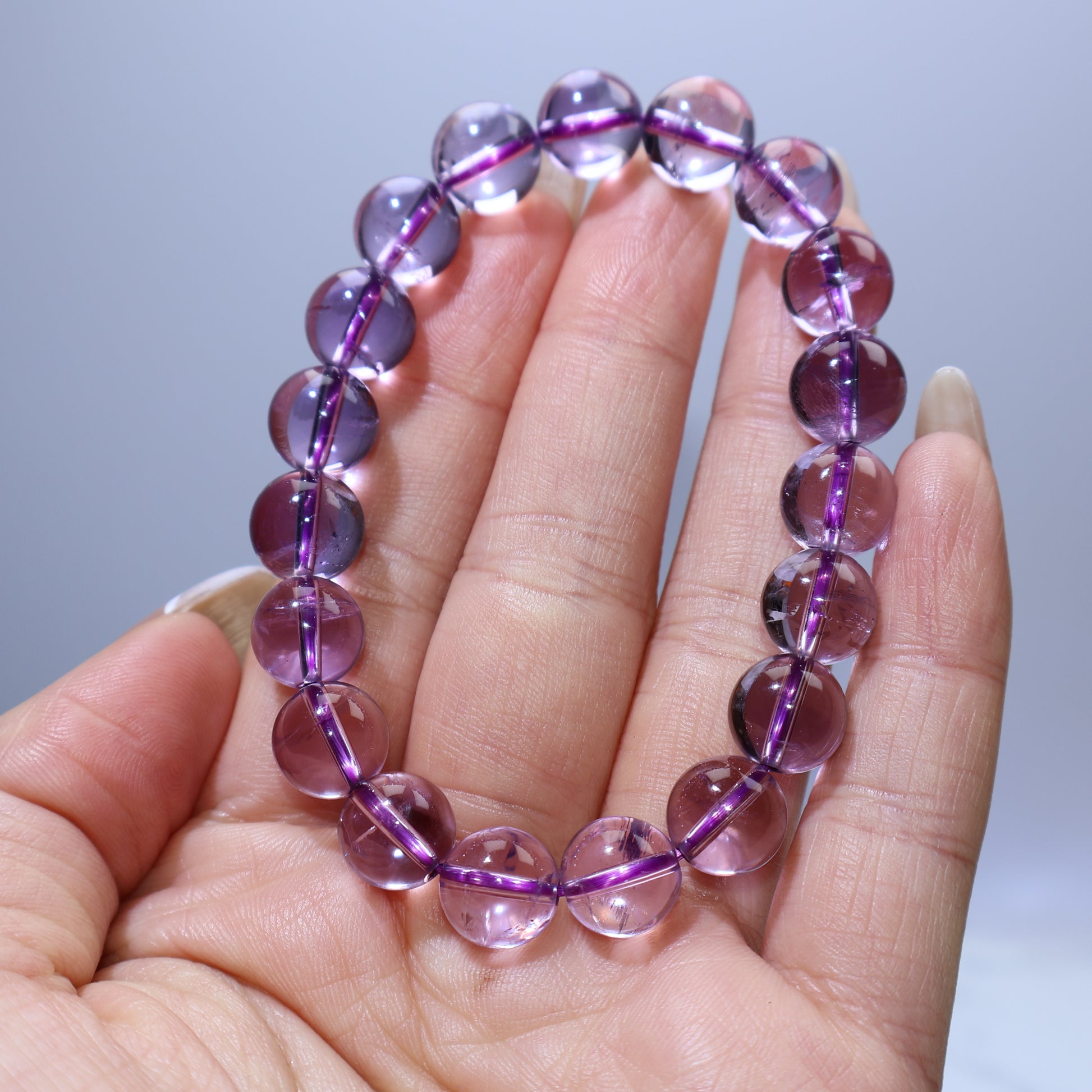 Handheld view showing transparent purple beads with internal ice cracks
