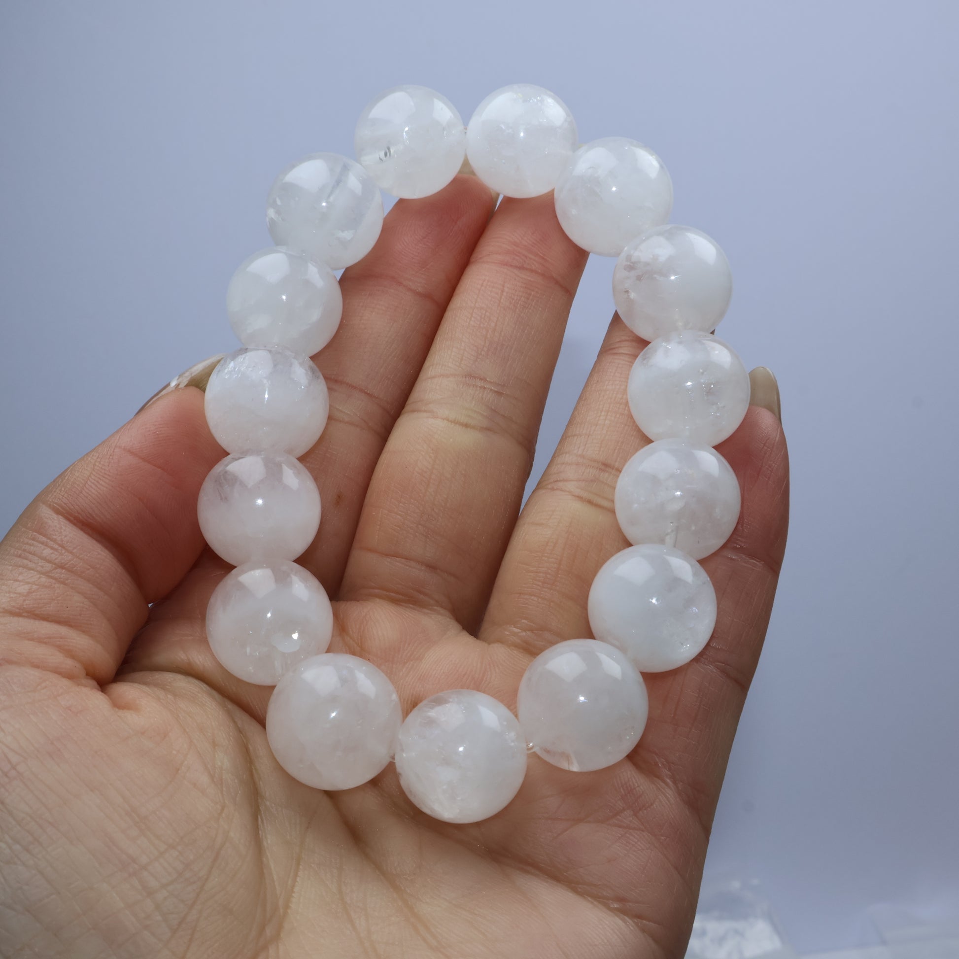 Handheld view of bracelet to show clarity, internal clouds, and bead size