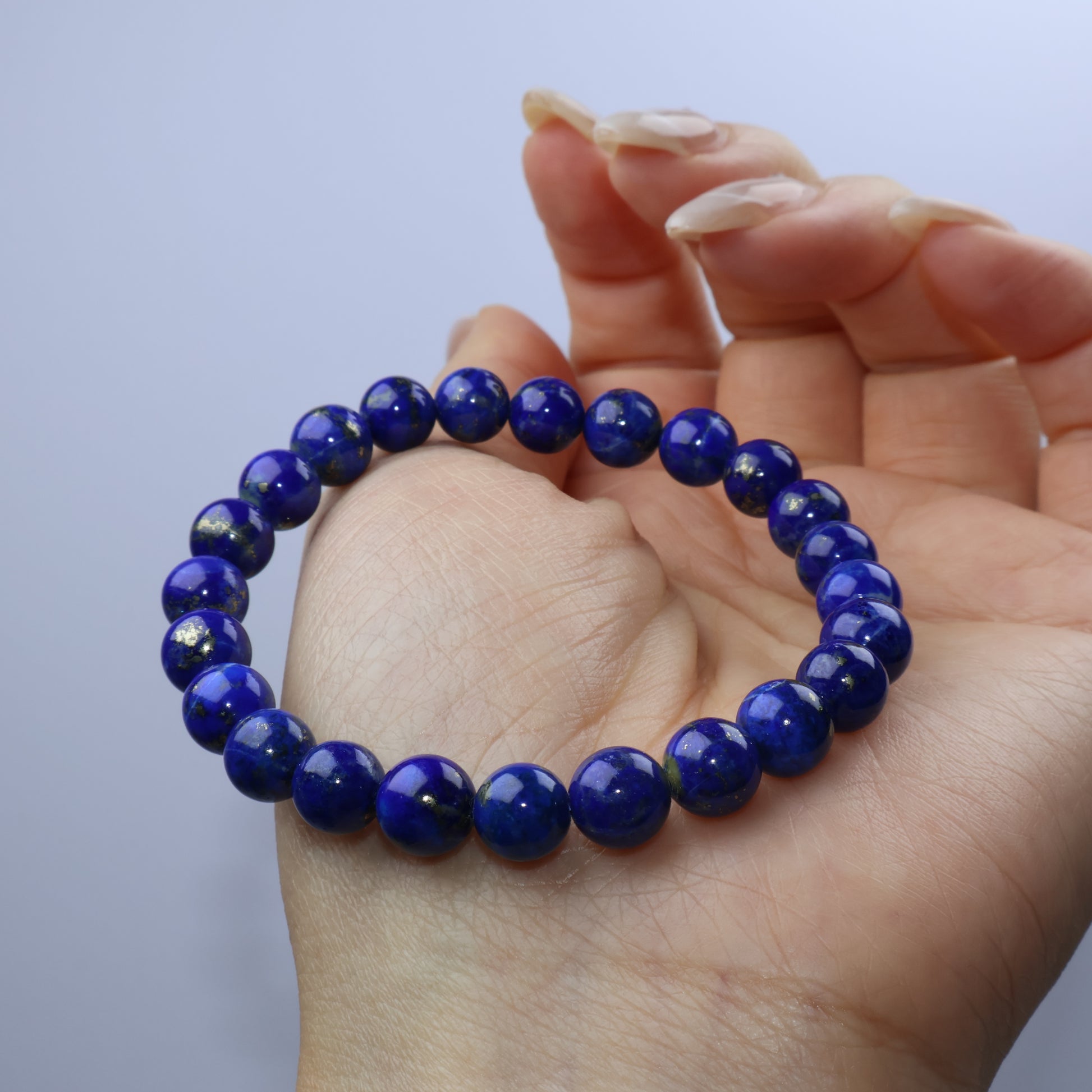 Bracelet held loosely in hand to show bead luster and flexibility