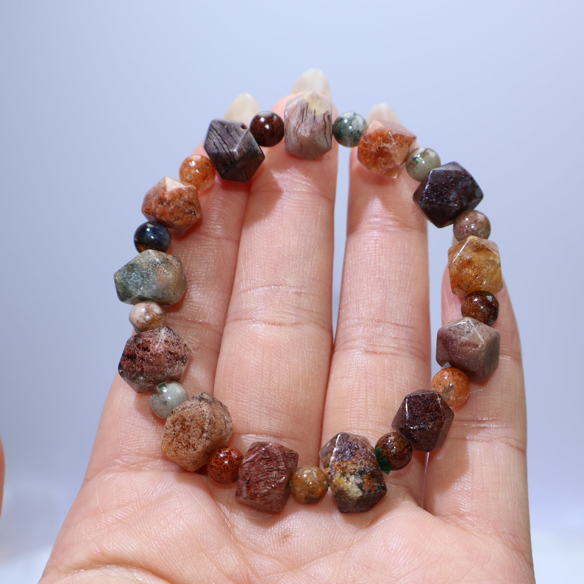 Handheld view highlighting polished round beads and internal landscapes