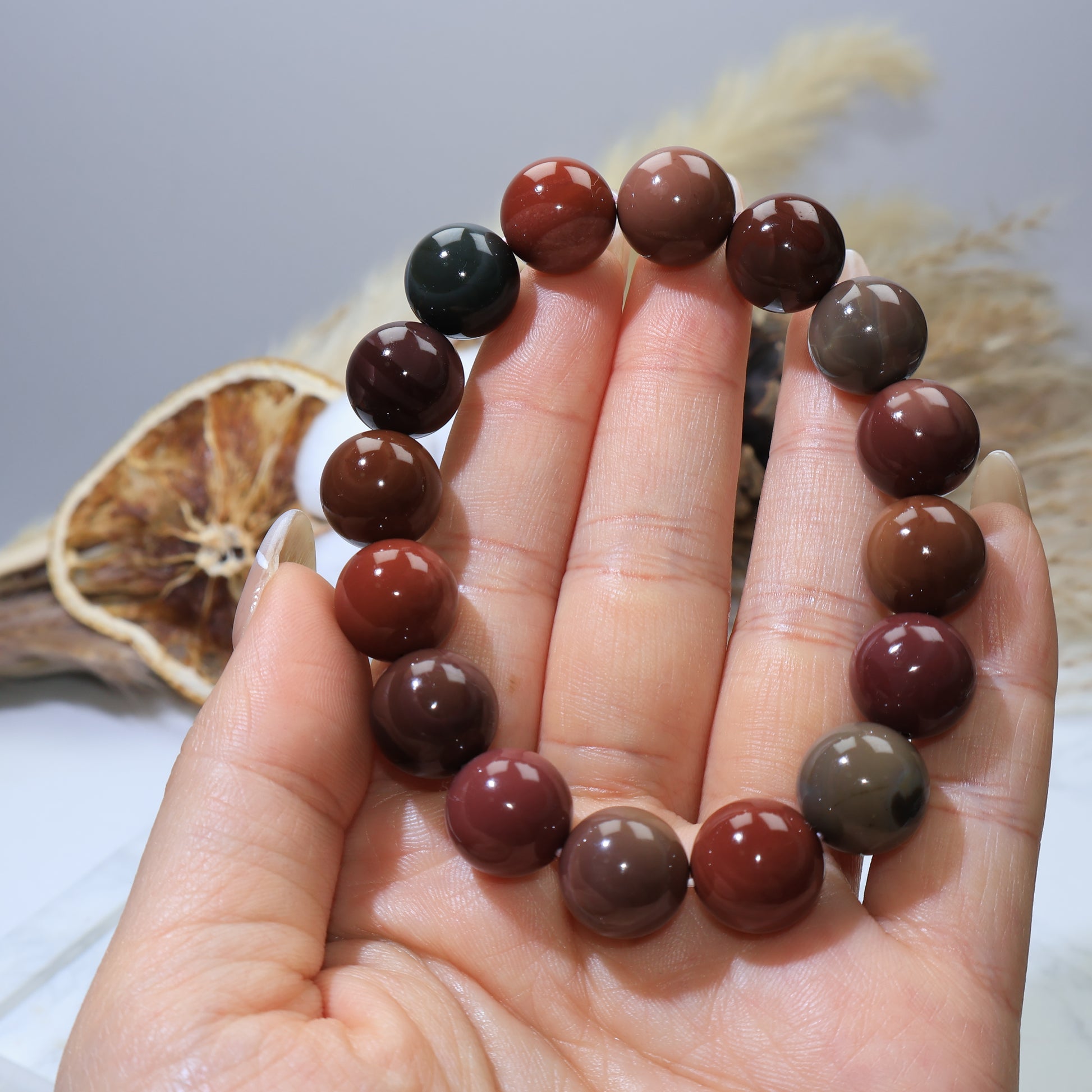 Handheld view of Alxa Agate bracelet showing bead size and smooth polish