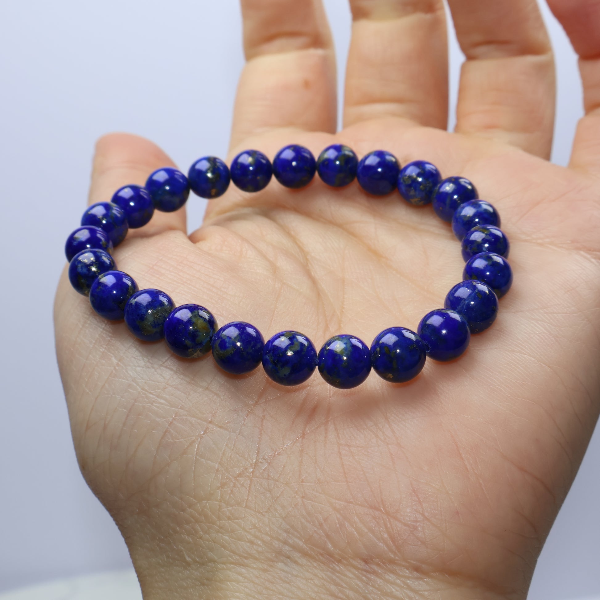 Close-up of a single Lapis Lazuli bracelet on hand, showcasing deep blue and pyrite specks