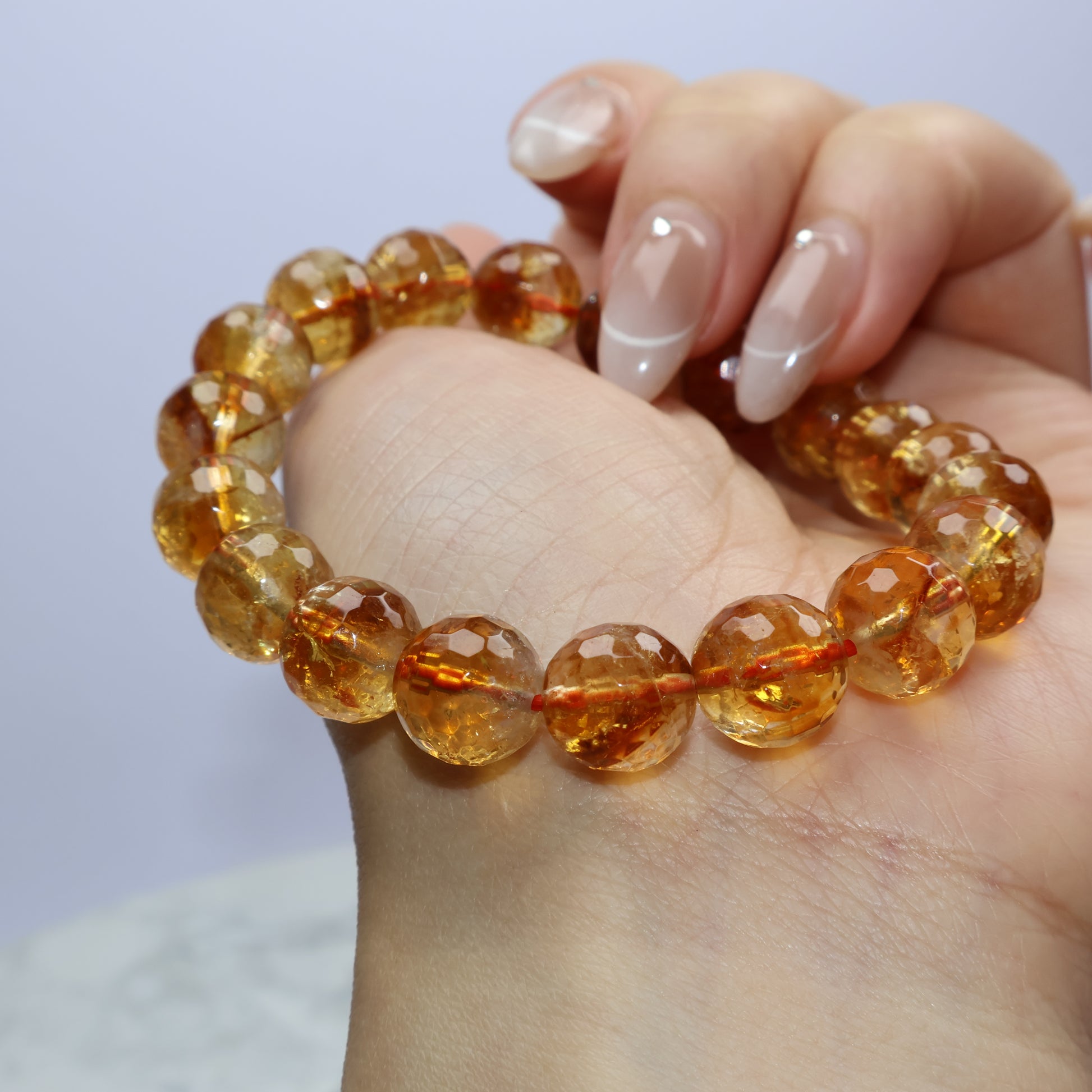 Side view of citrine bracelet resting on palm, highlighting faceted reflections and earthy texture