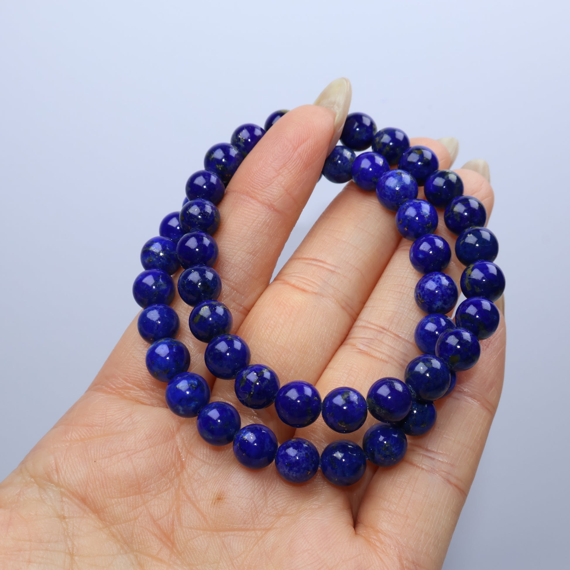 Two bracelets layered on fingers for color and quality comparison