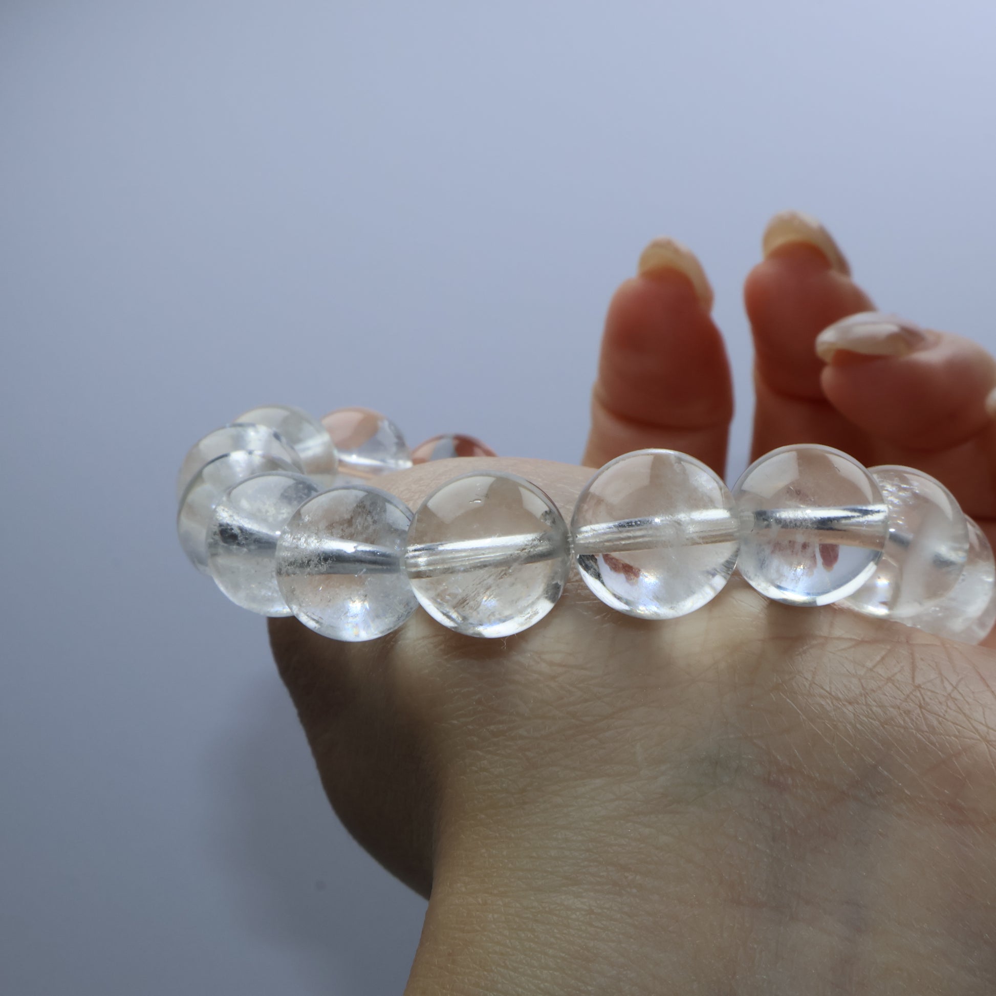 Close-up of clear quartz bracelet worn on wrist with soft lighting