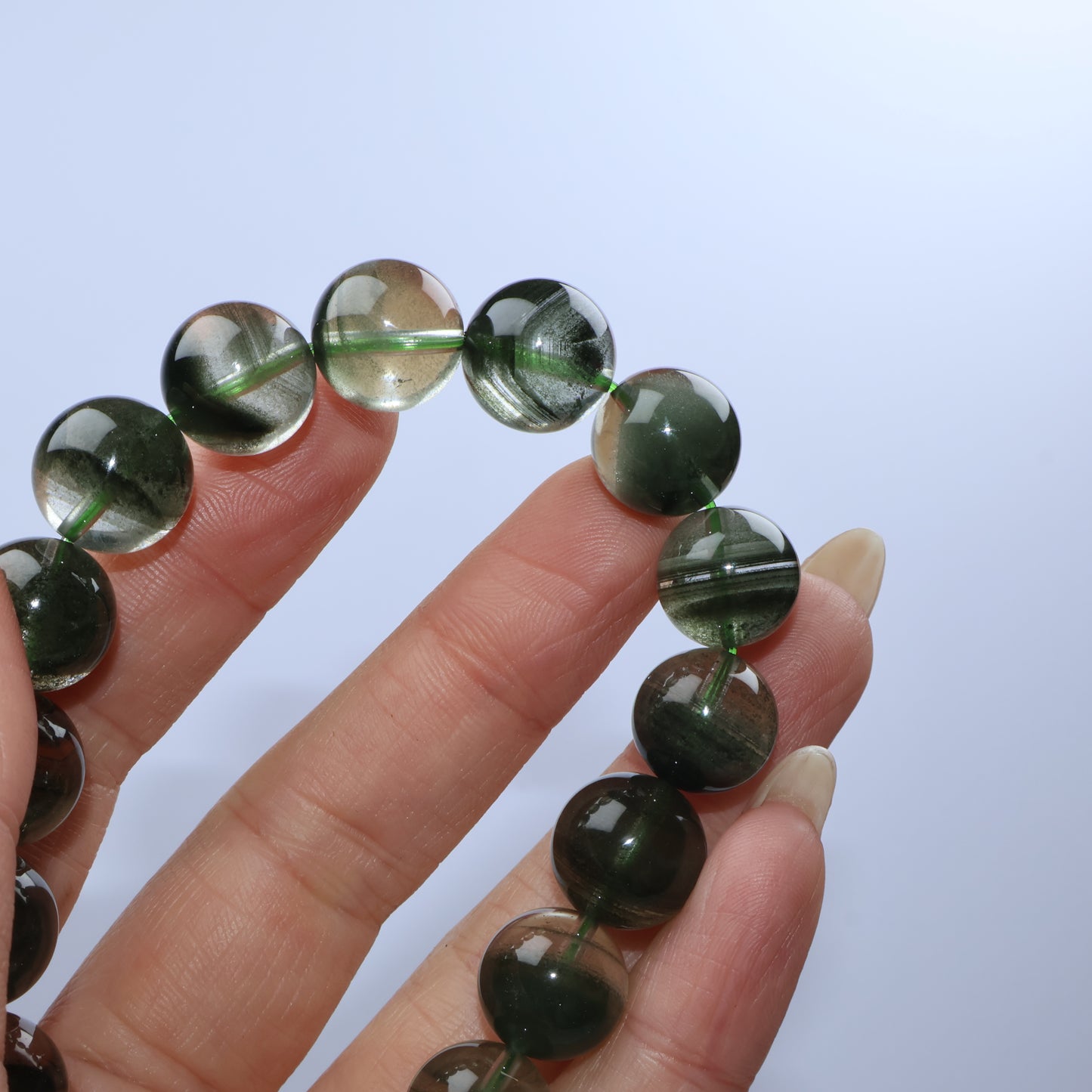Focus on light reflection through beads highlighting green inclusions