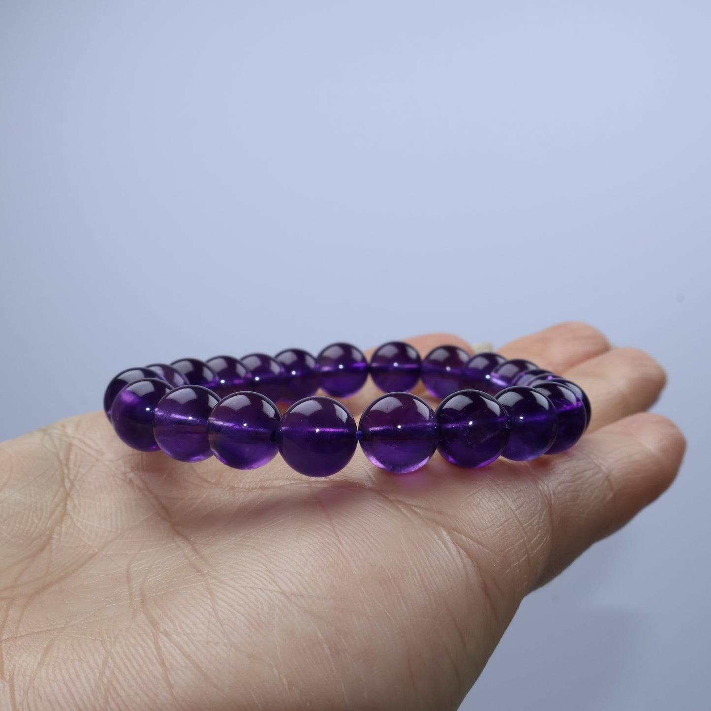 Bracelet draped on palm showing crystal clarity under soft light