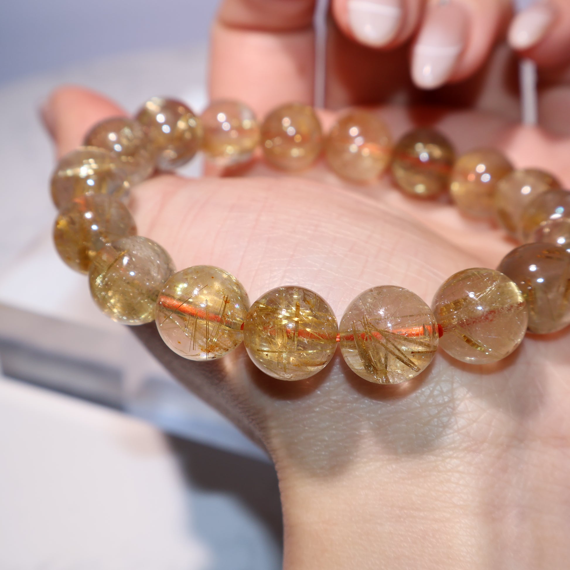 Side angle close-up of rutile threads in 11mm golden quartz beads