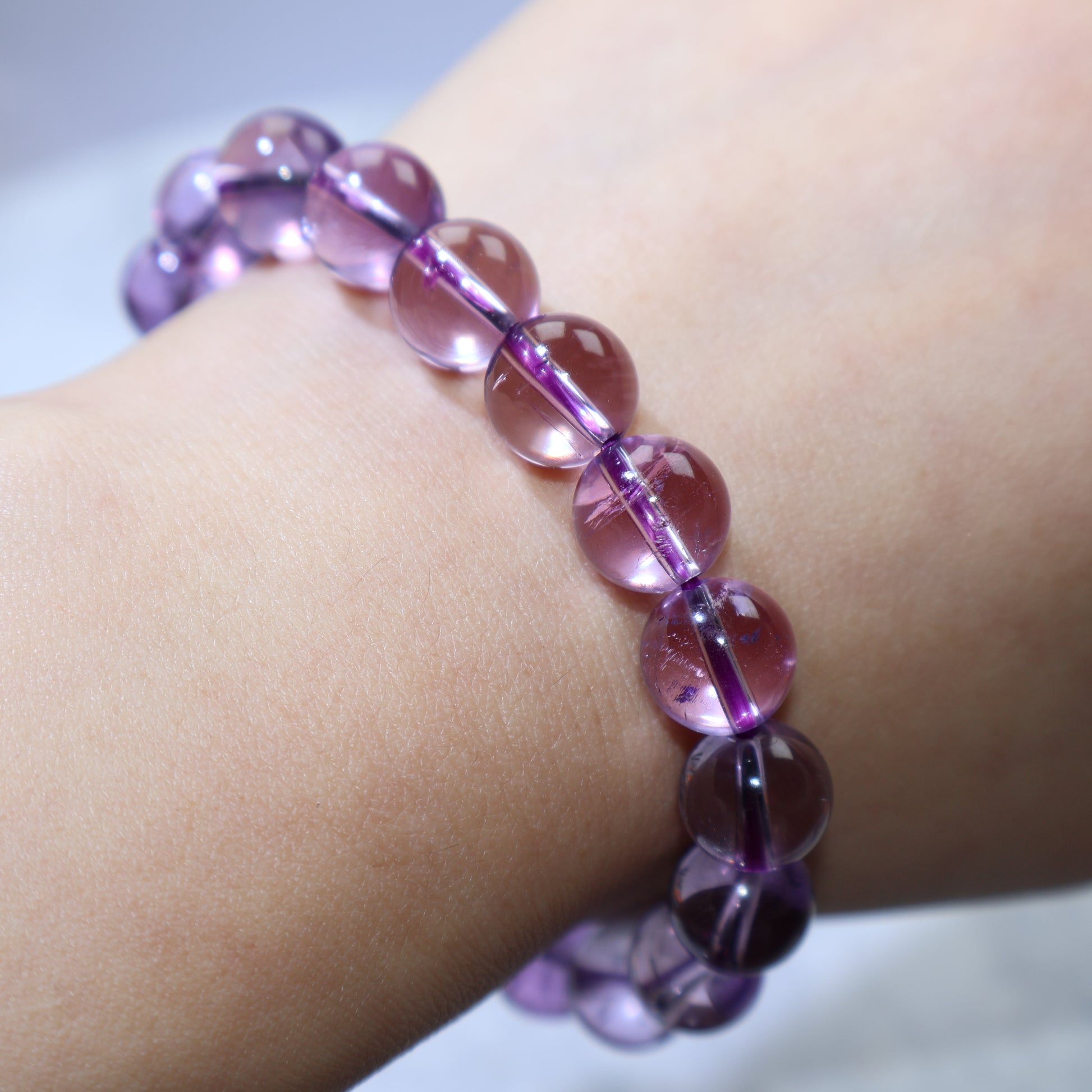 Bracelet draped over hand under soft light to enhance crystal clarity