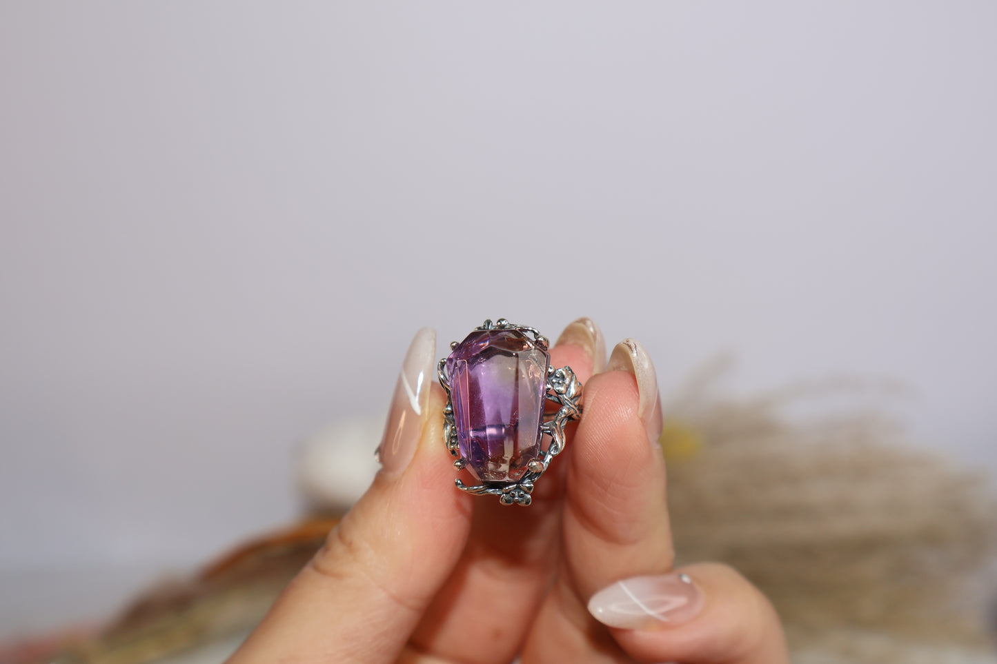 Close-up of freeform faceted Ametrine crystal in oxidized silver botanical setting