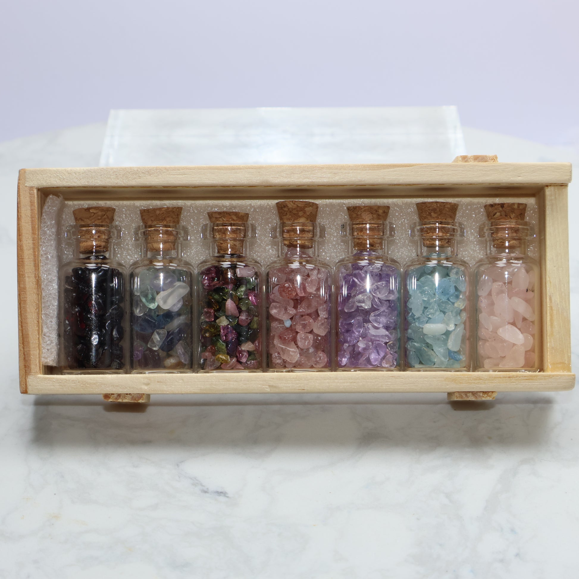 Top-down photo of crystal energy bottles neatly arranged in wooden box