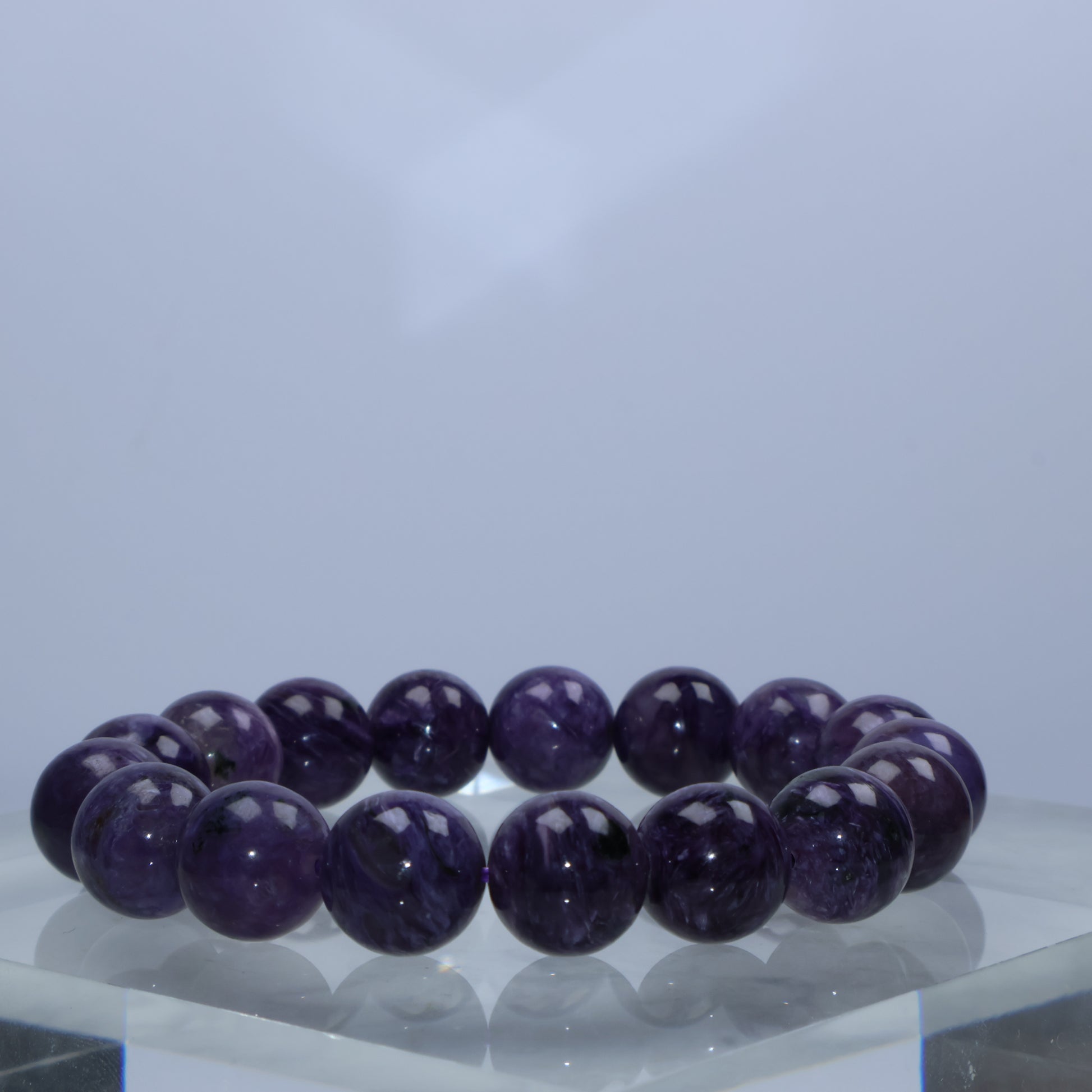Side angle of Charoite beads showing silky patterns under studio light