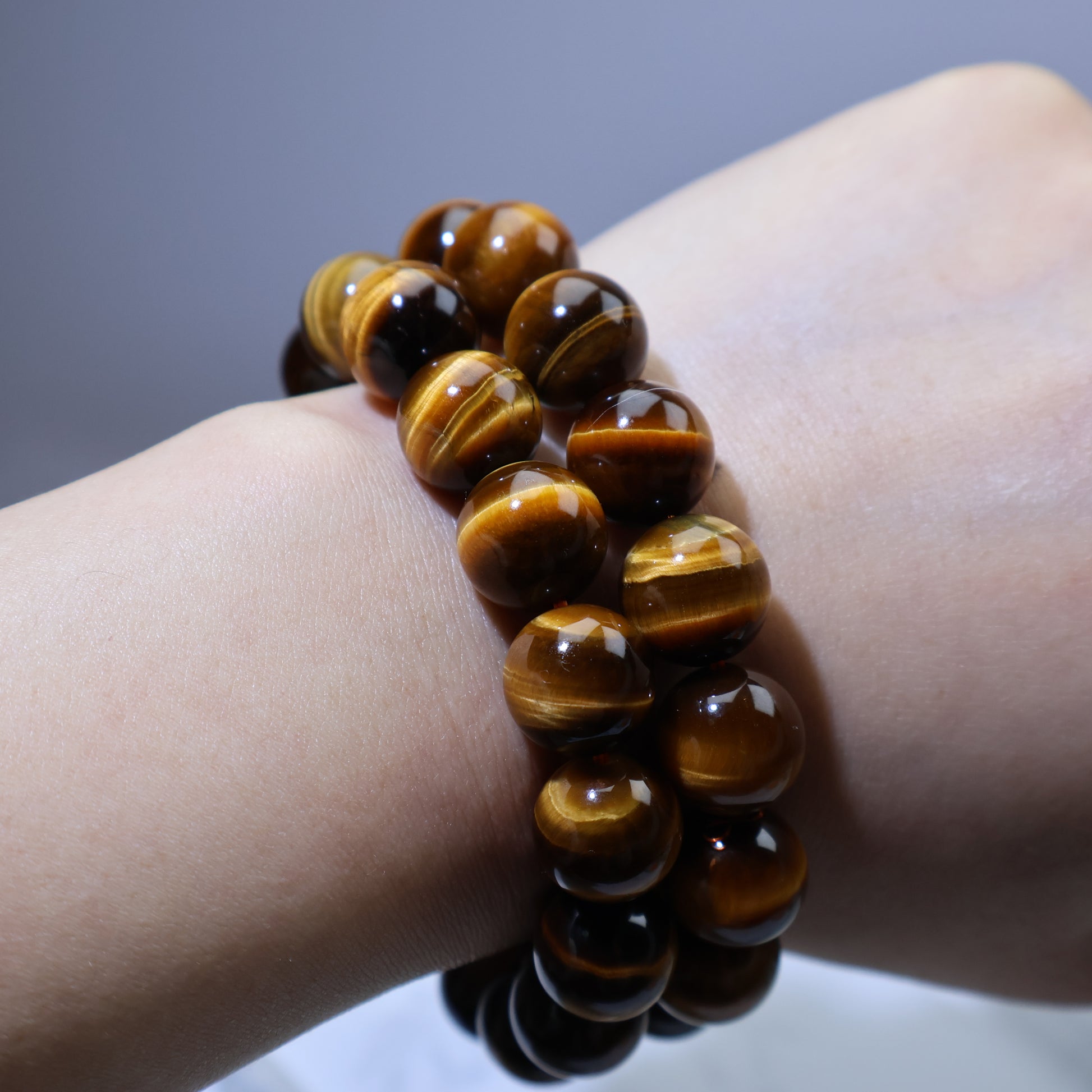 Stacked wrist shot showing layered Tiger’s Eye bracelets