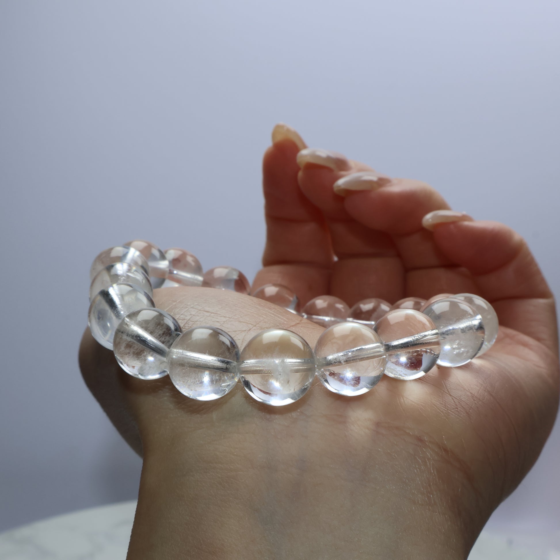Close-up of clear quartz bracelet worn on wrist with soft lighting