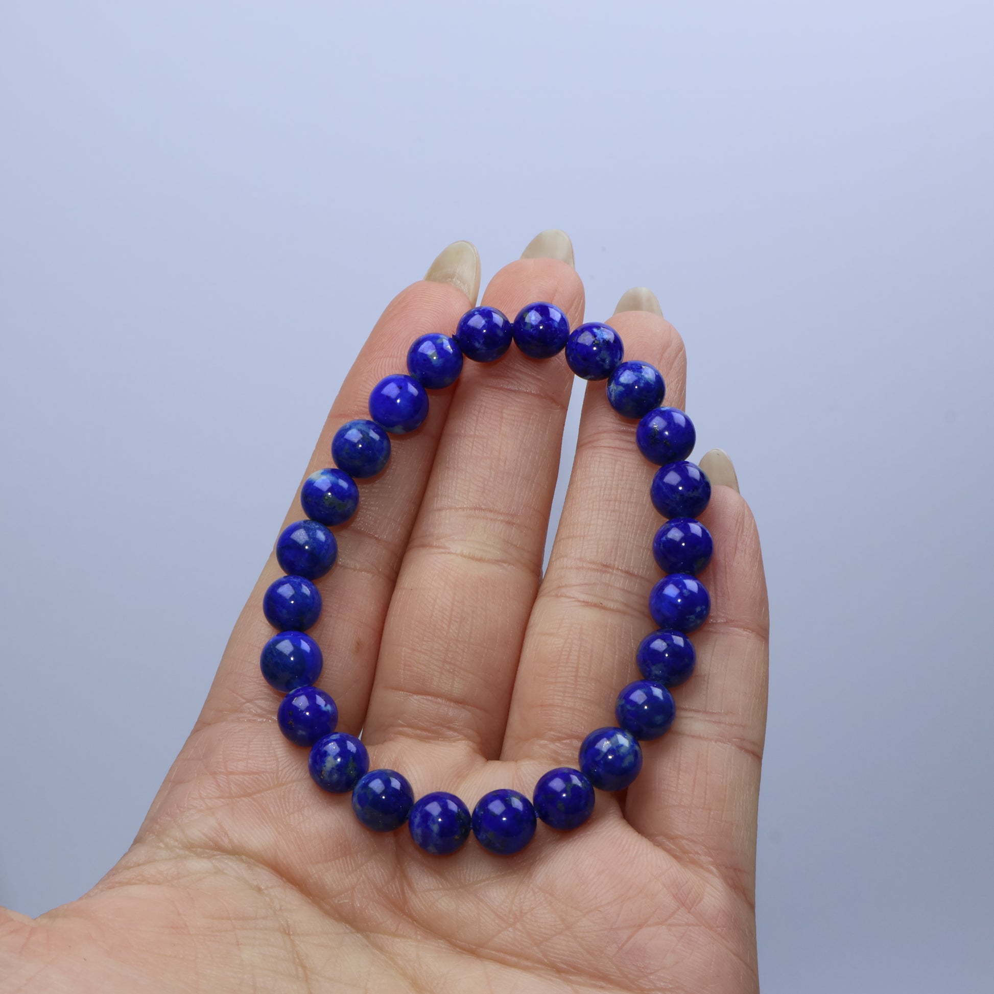 Close-up of a single Lapis Lazuli bracelet on hand, showcasing deep blue and pyrite specks