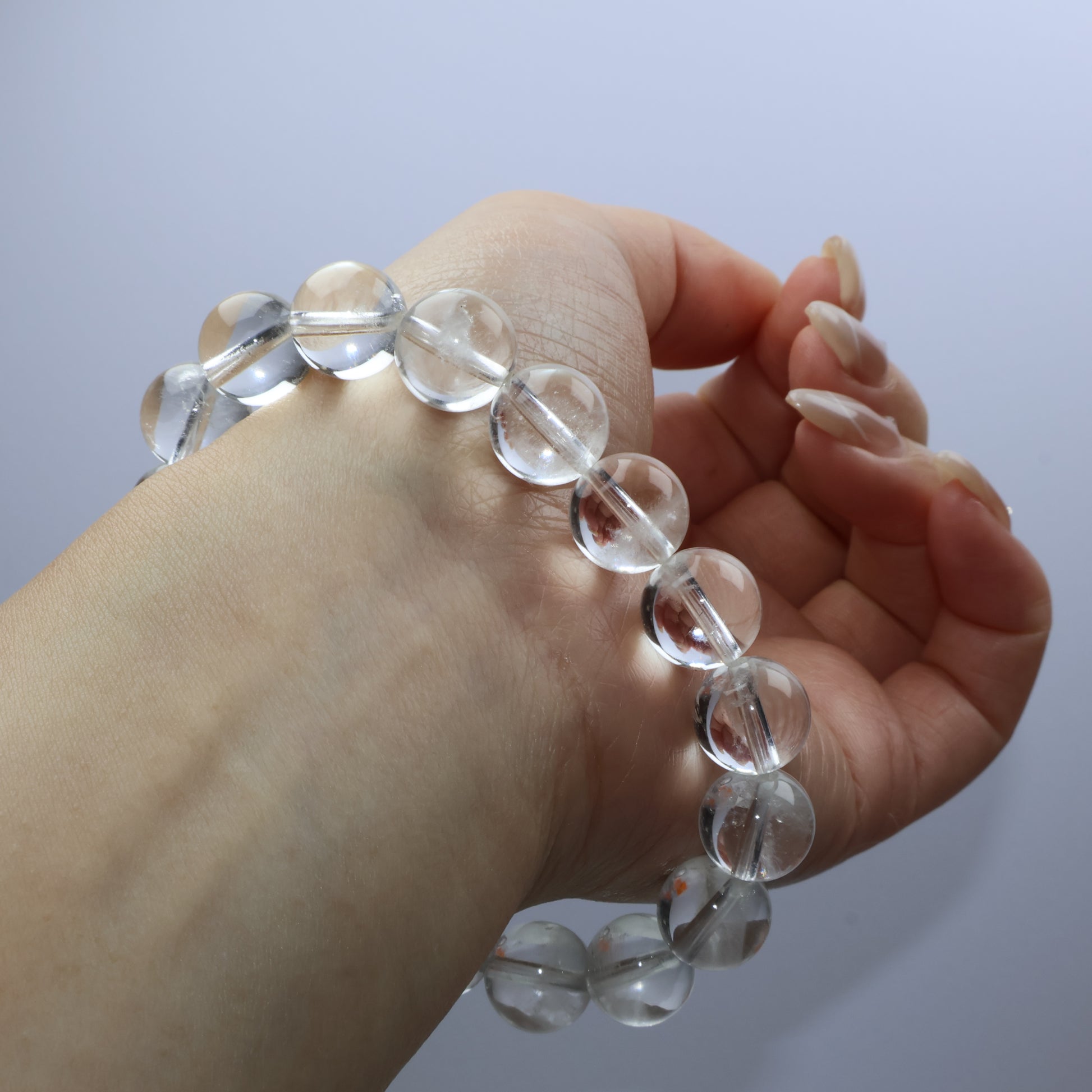 Elegant view of clear quartz bracelet on wrist, highlighting the translucent beads and subtle internal textures