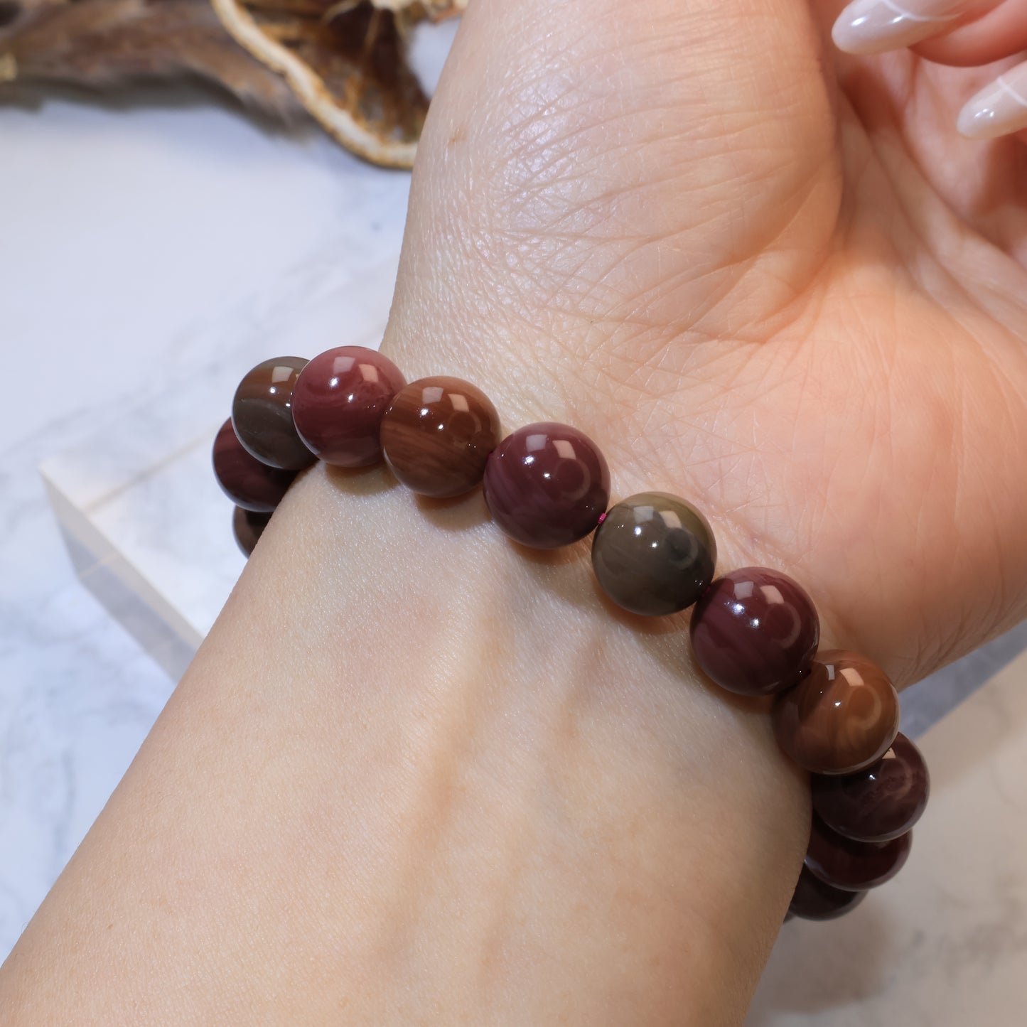 Side wrist angle of Mookaite Jasper bracelet emphasizing bead polish and color variation