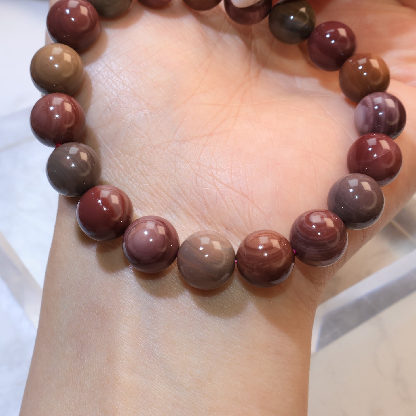 Mookaite Jasper bracelet displayed on palm under soft light
