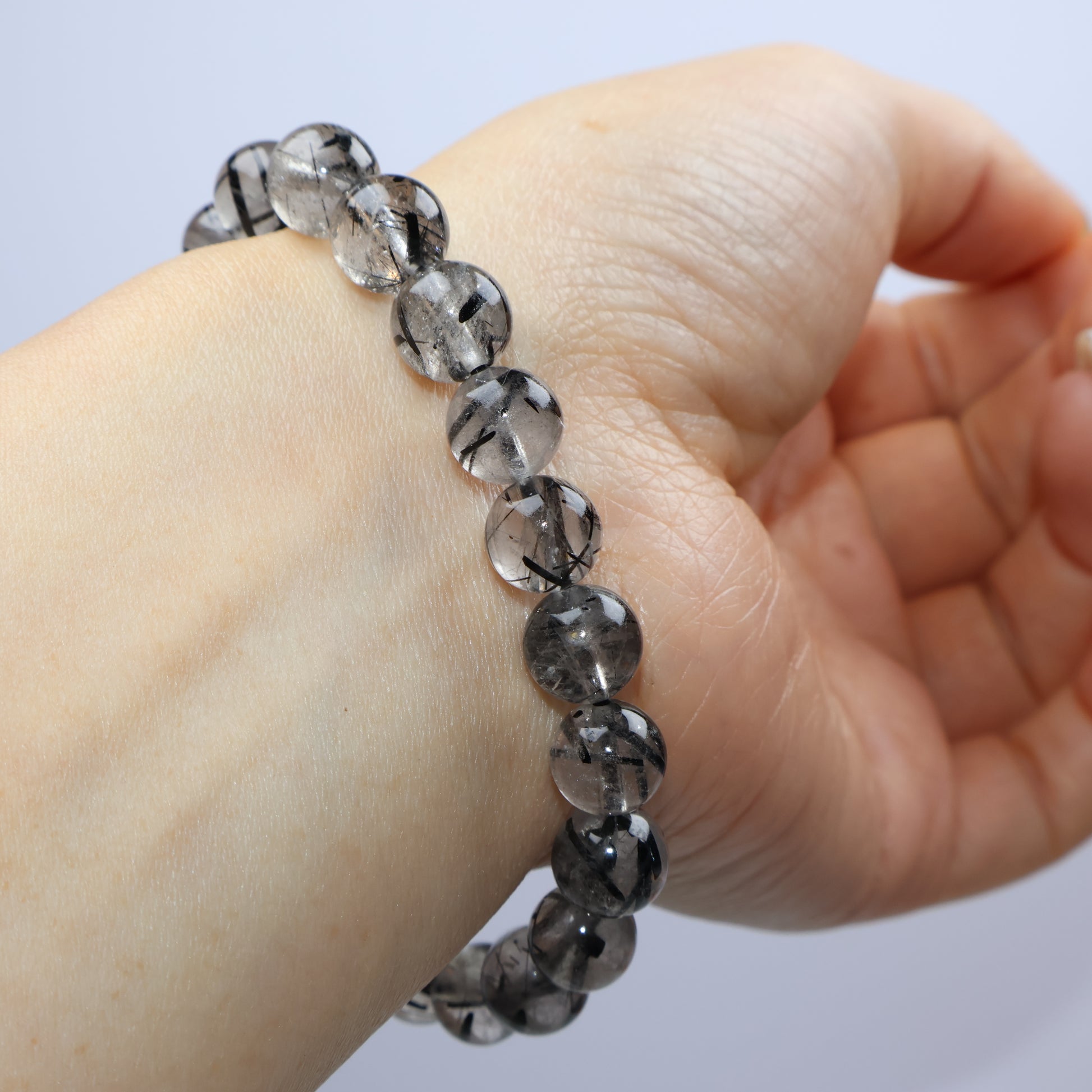 Natural light reflection on thick rutile lines in translucent quartz