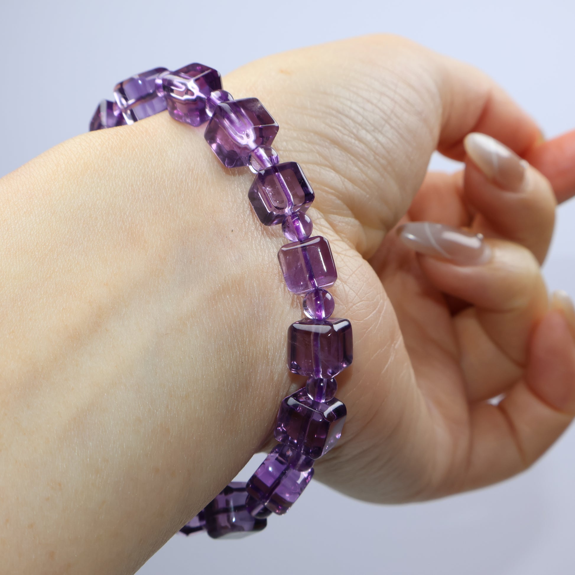 Close-up of the bracelet on wrist, capturing clean cuts and radiant purple glow