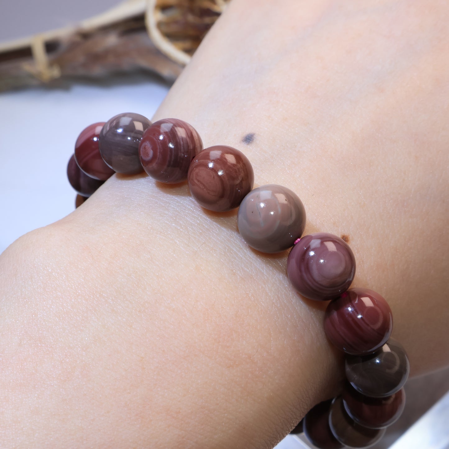 Mookaite Jasper bracelet worn on wrist, showcasing mix of red, brown, and green hues