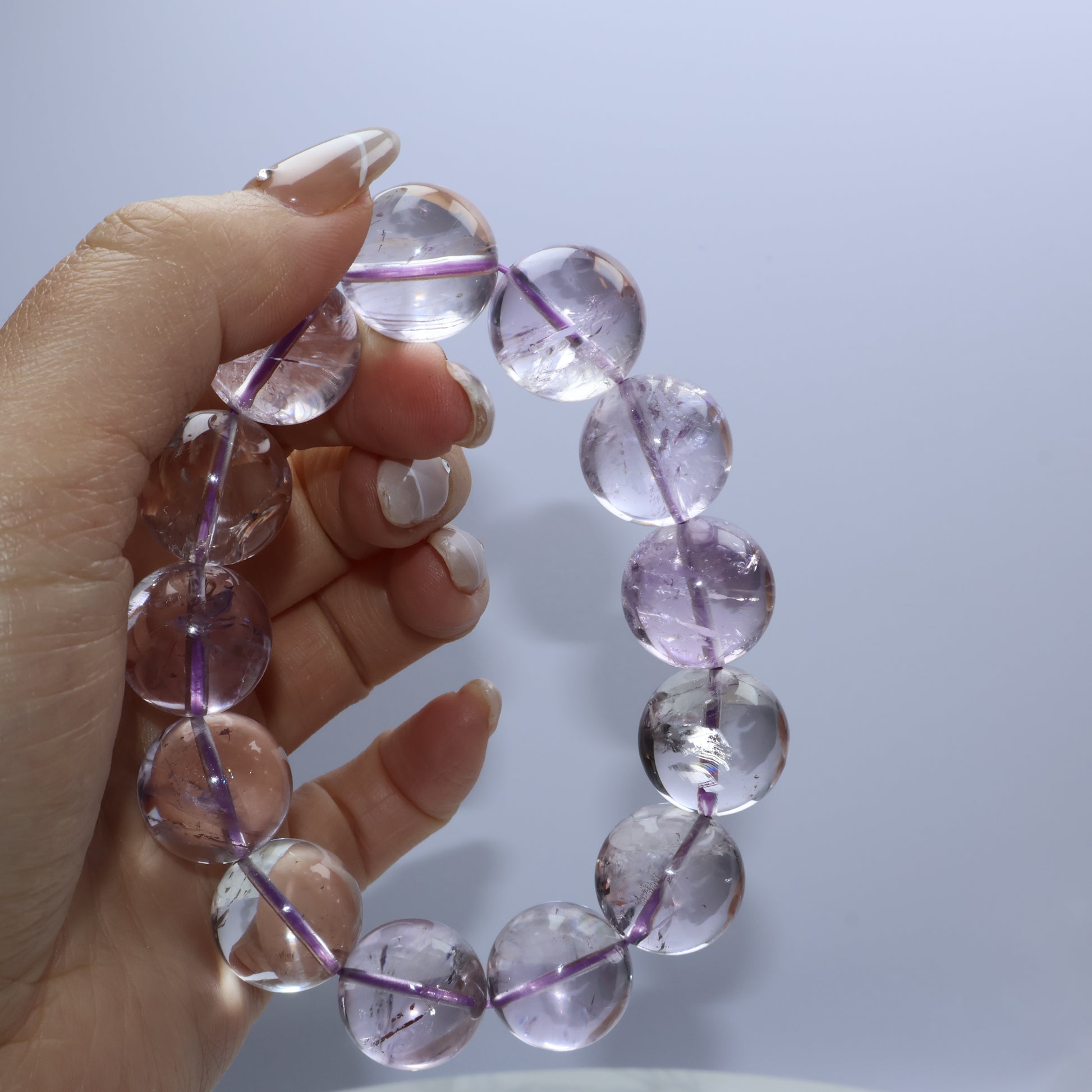Light reflecting through clear amethyst beads on hand