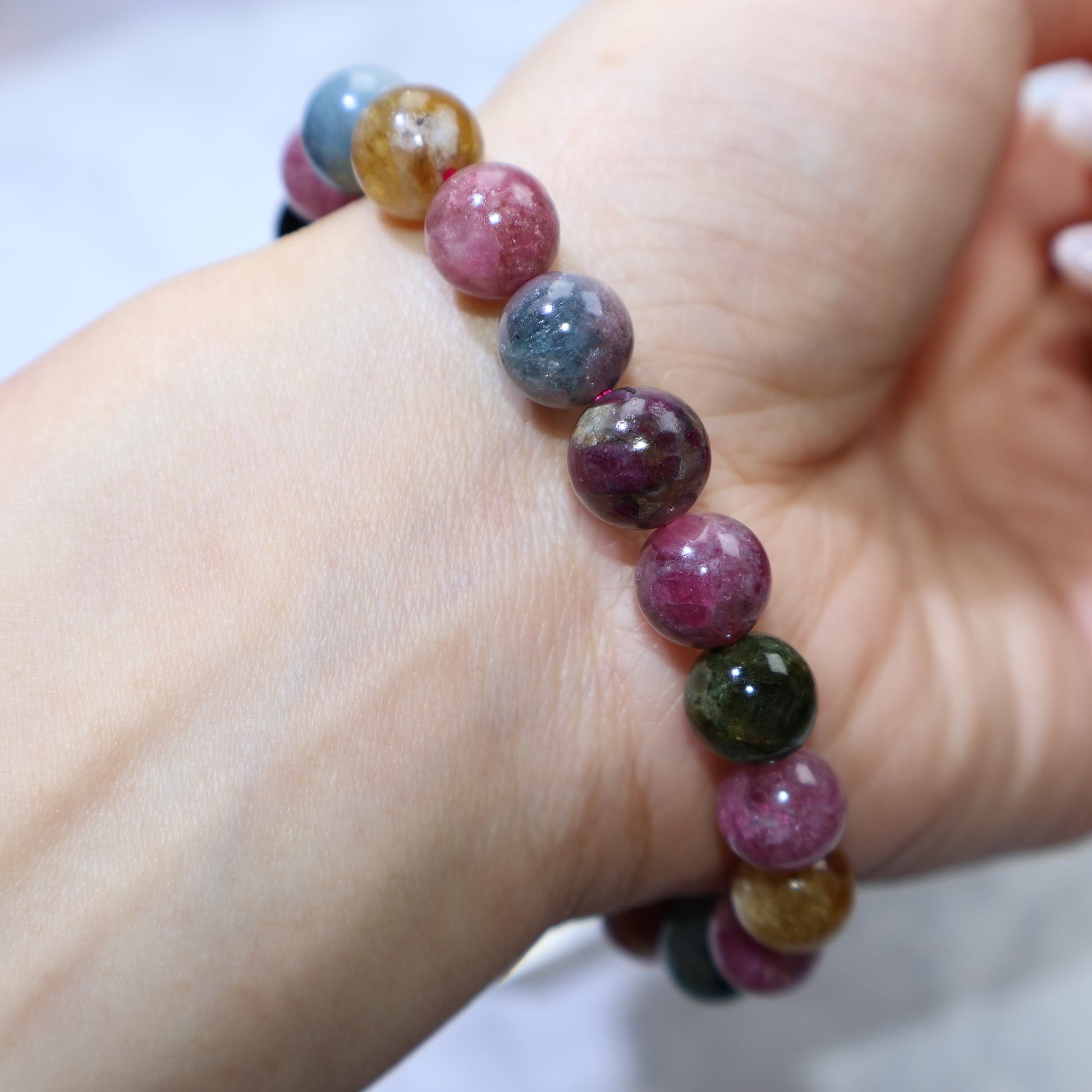 Angled wrist shot showing gemstone luster and harmonious color mix