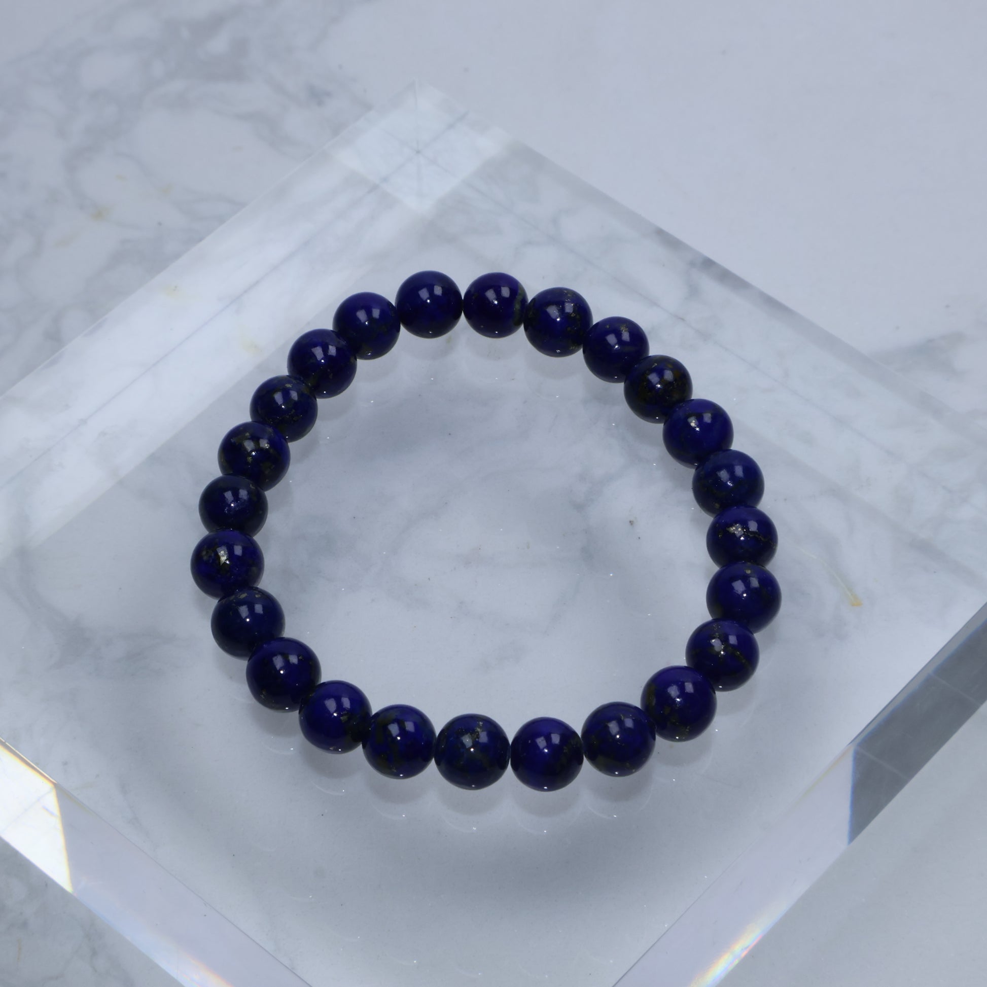 Flat lay of upgraded 7mm lapis lazuli bracelet on acrylic block – clean display