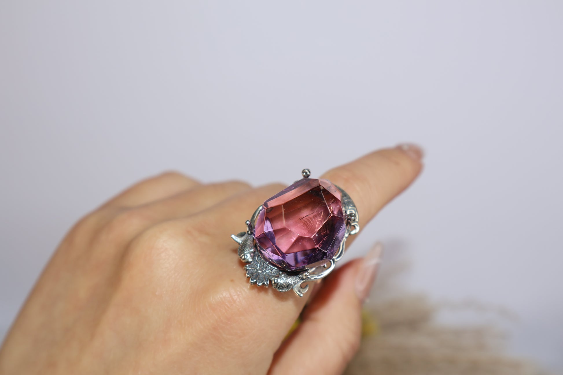 Mystical twin fish Ametrine ring worn on finger, showing light reflection