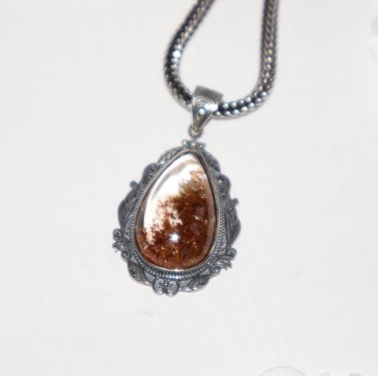 Close-up of Phantom Quartz pendant with reddish-brown inclusions in ornate S925 silver setting