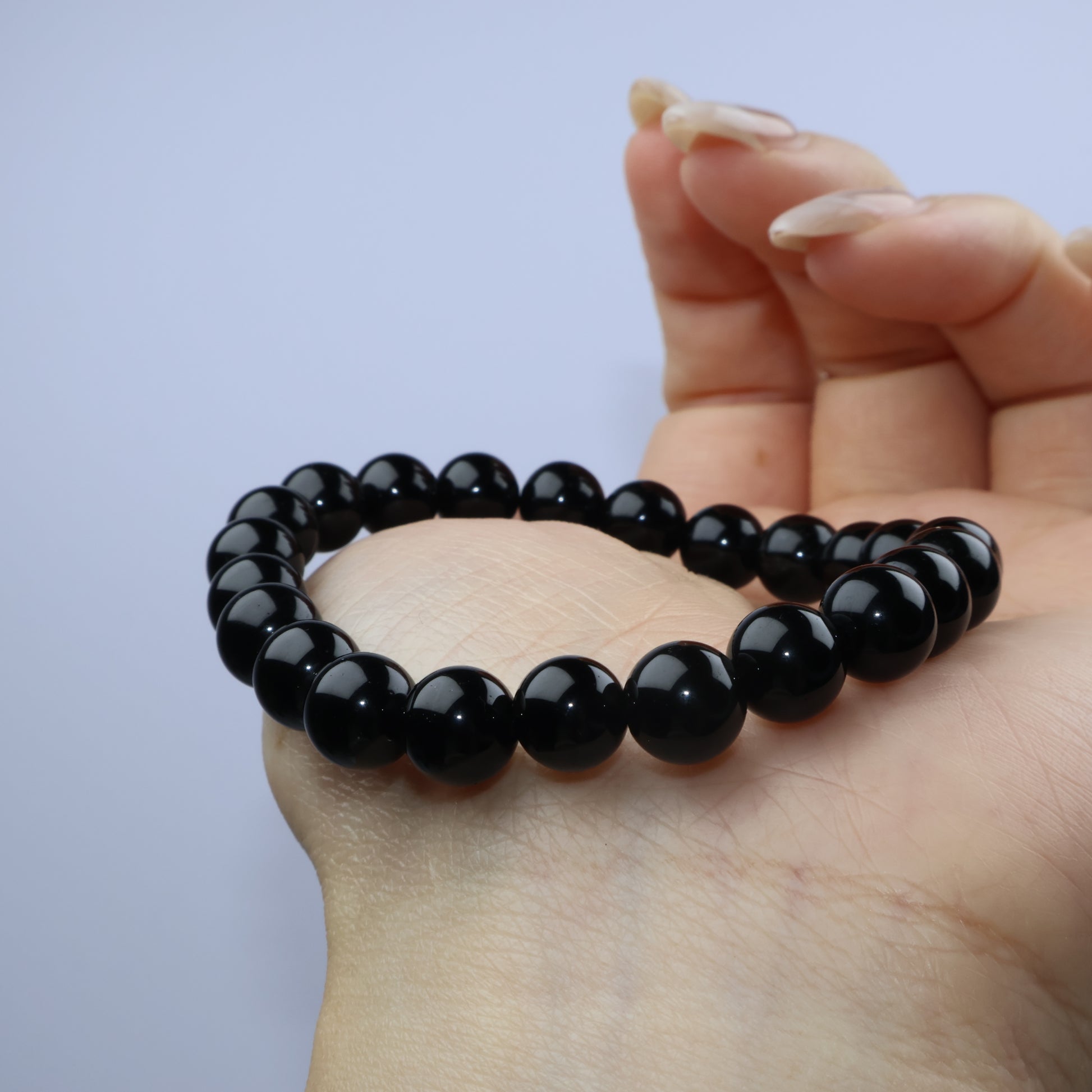 Macro shot of black obsidian bead, highlighting reflective surface and minor inclusions