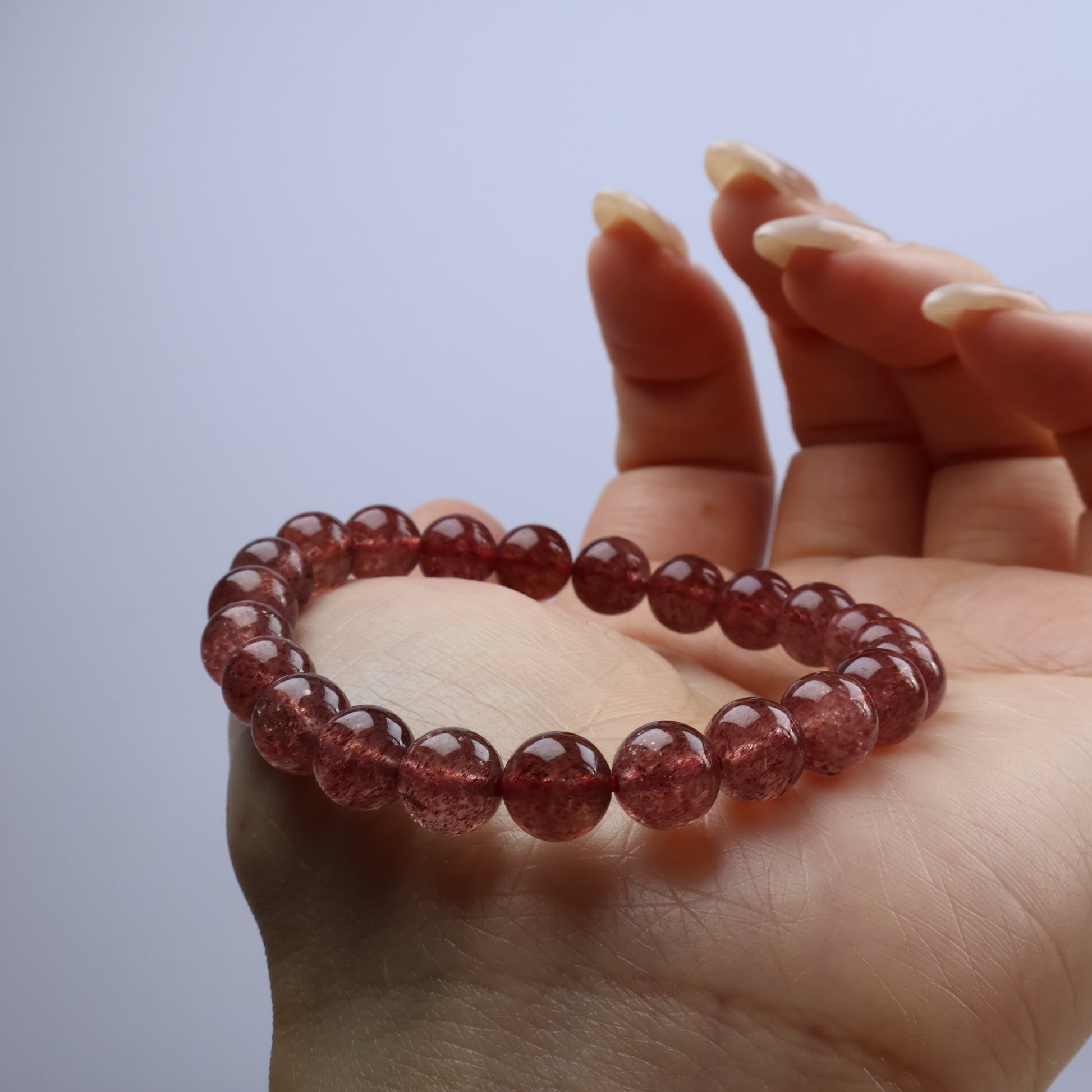 Side angle of bracelet on palm highlighting clarity and speckled inclusions