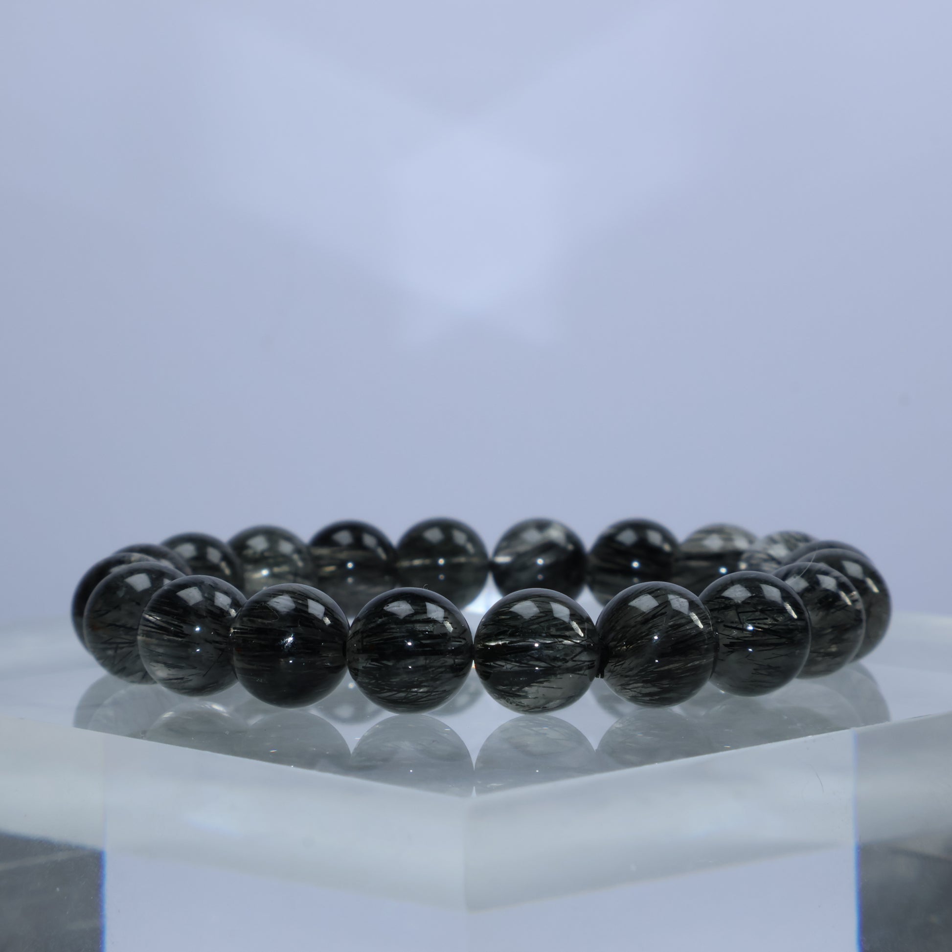 Side angle showcasing black rutile threads and polished finish