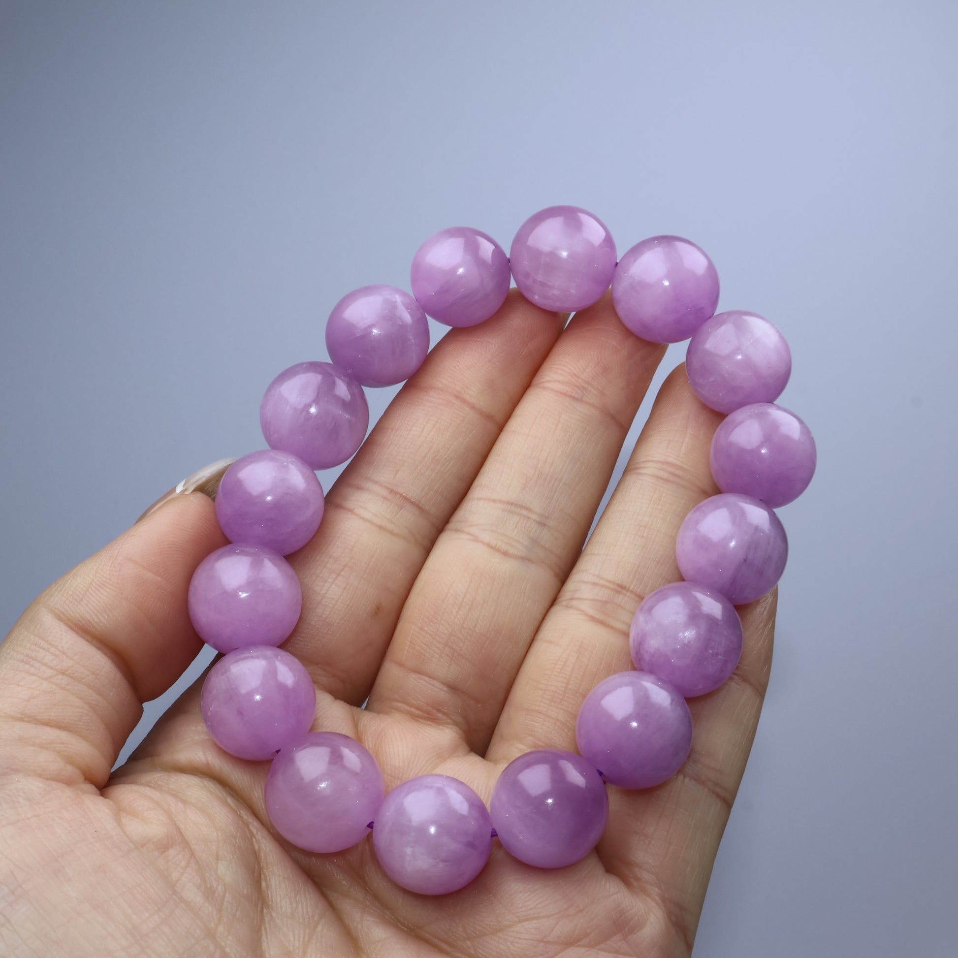 Handheld shot of Lepidolite bracelet with uniform pastel purple hue