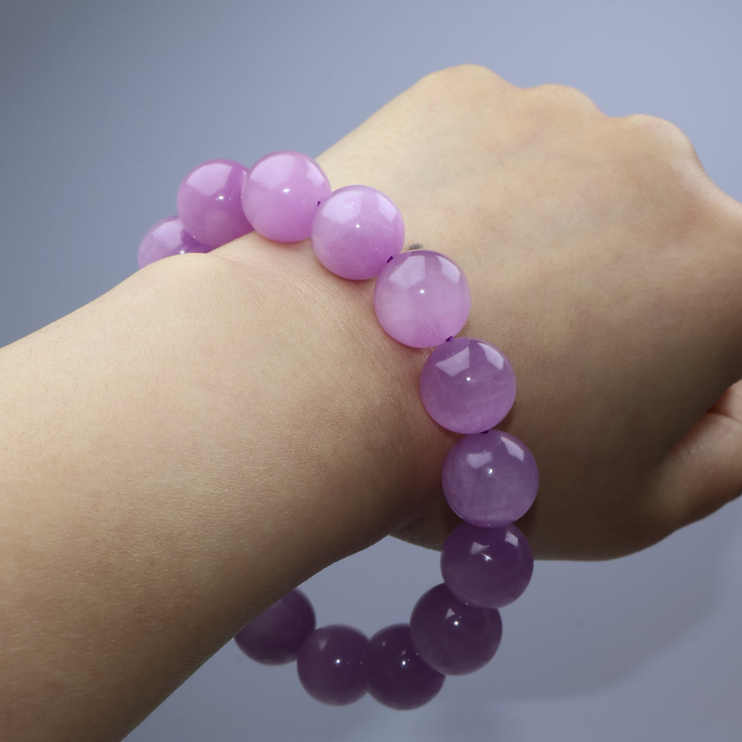 Bracelet resting across back of hand, showing bead size and polished surface