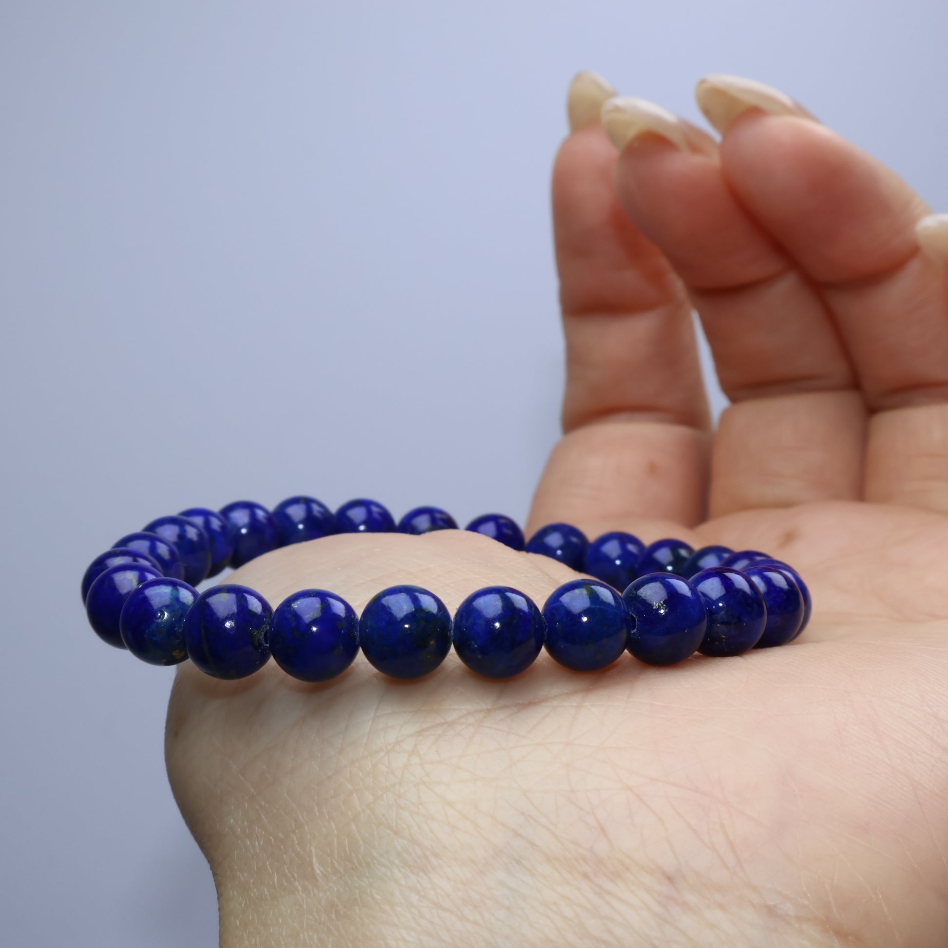 Side view of Lapis bracelet resting over hand with no visible white inclusions